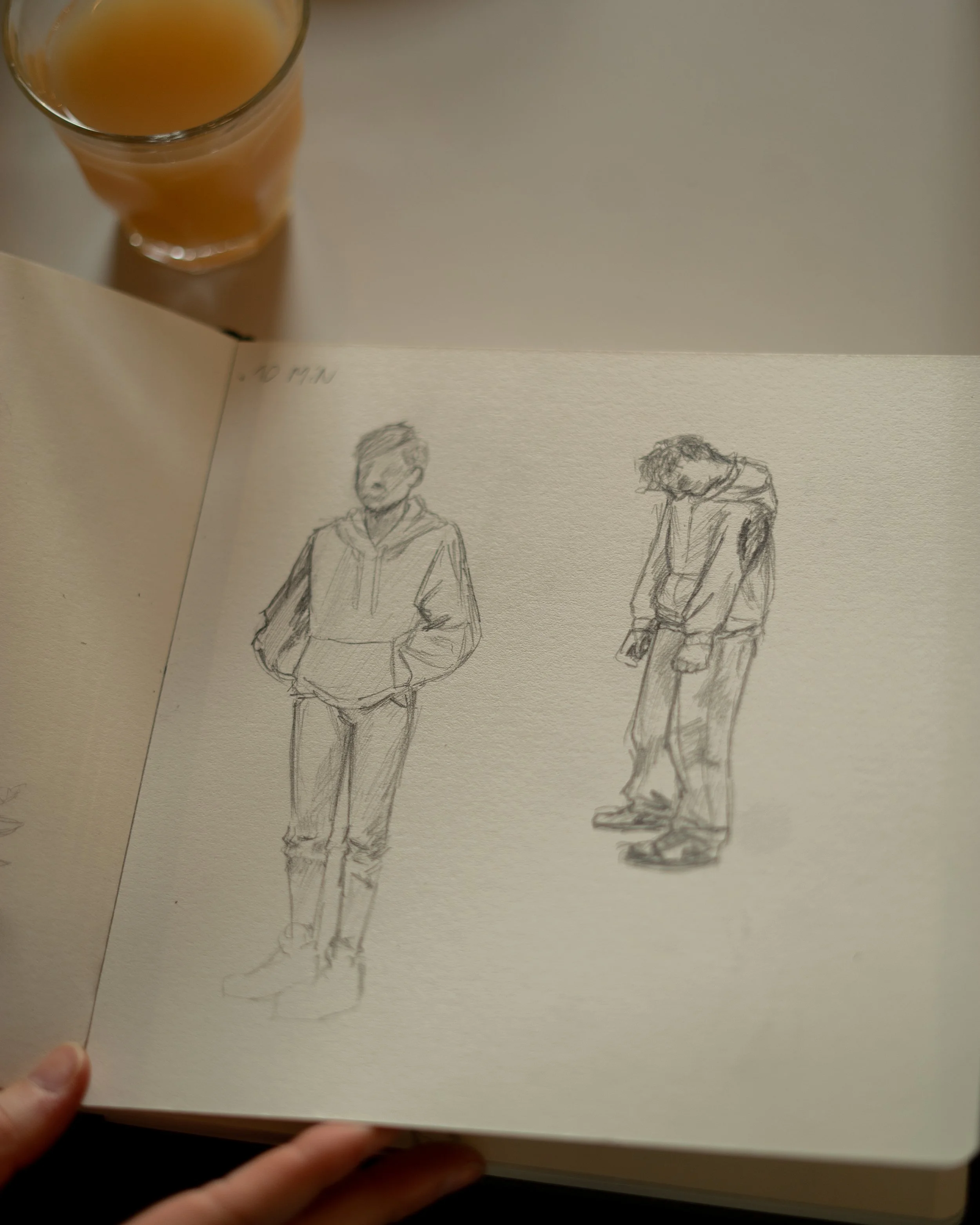 Twee schetsen van mensen in een schetsboek, een man staat rechtop met handen in zakken en een vrouw buigt met hoofd naar beneden. Striptekenen en animeren bij Skill School