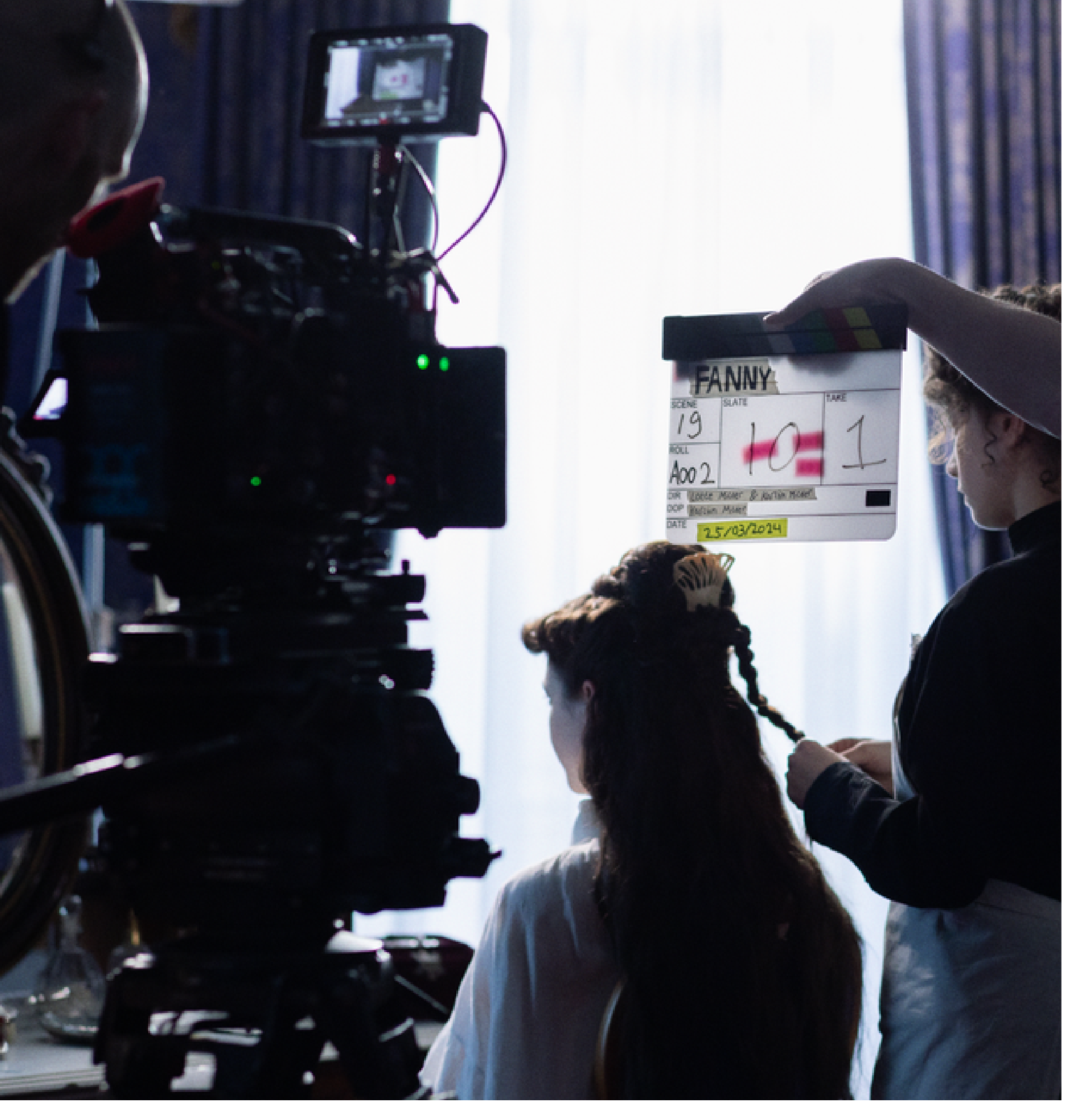 Filmcrew op set met een clapperboard en een cameraploeg richt zich op een actrice die haar haar wordt gedaan. Filmen en editen bij Skill School