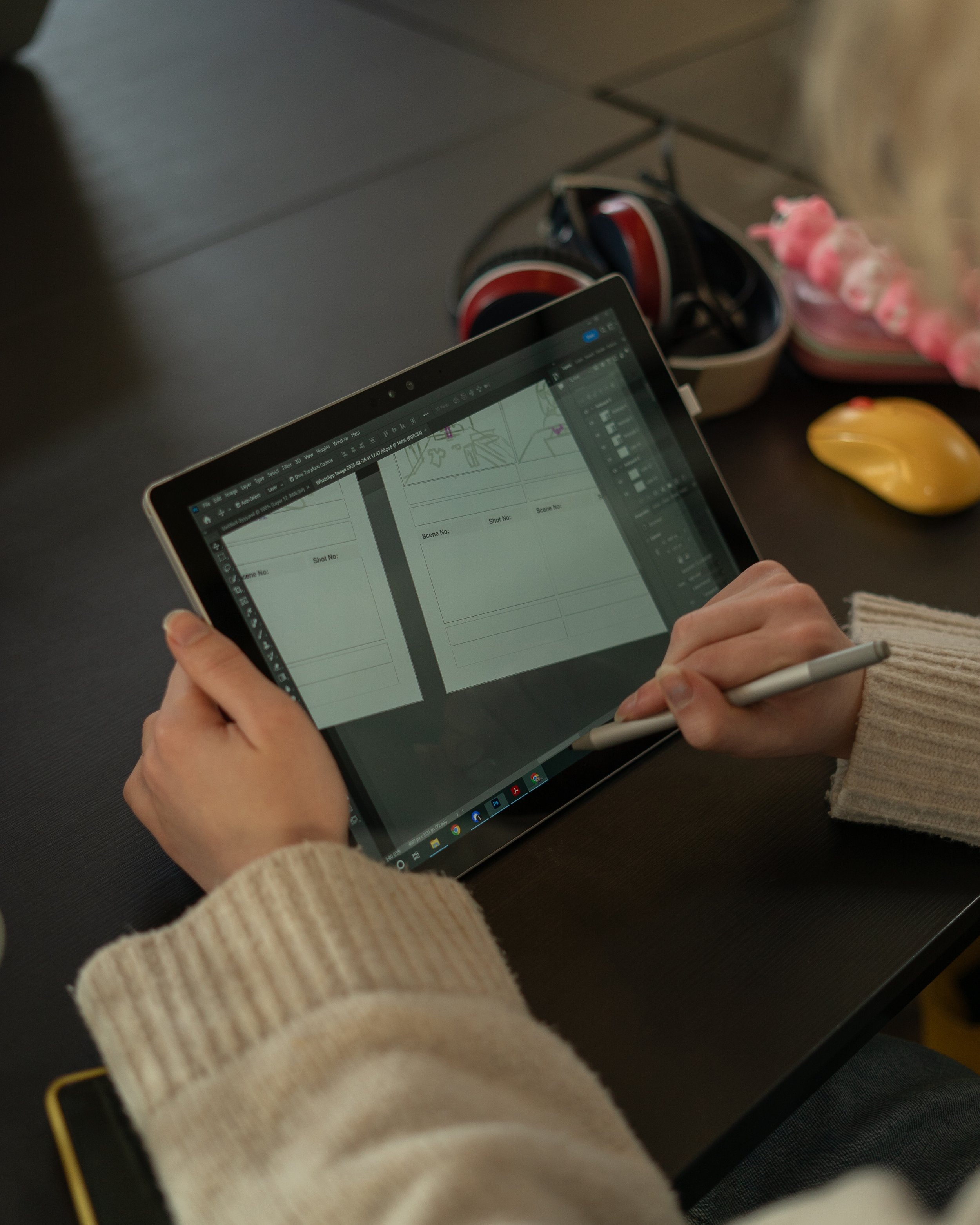 Een persoon die een digitale tekentafel of tablet gebruikt om een storyboard te maken, met een pen in de hand. Graphic design leerlijn bij Skill School