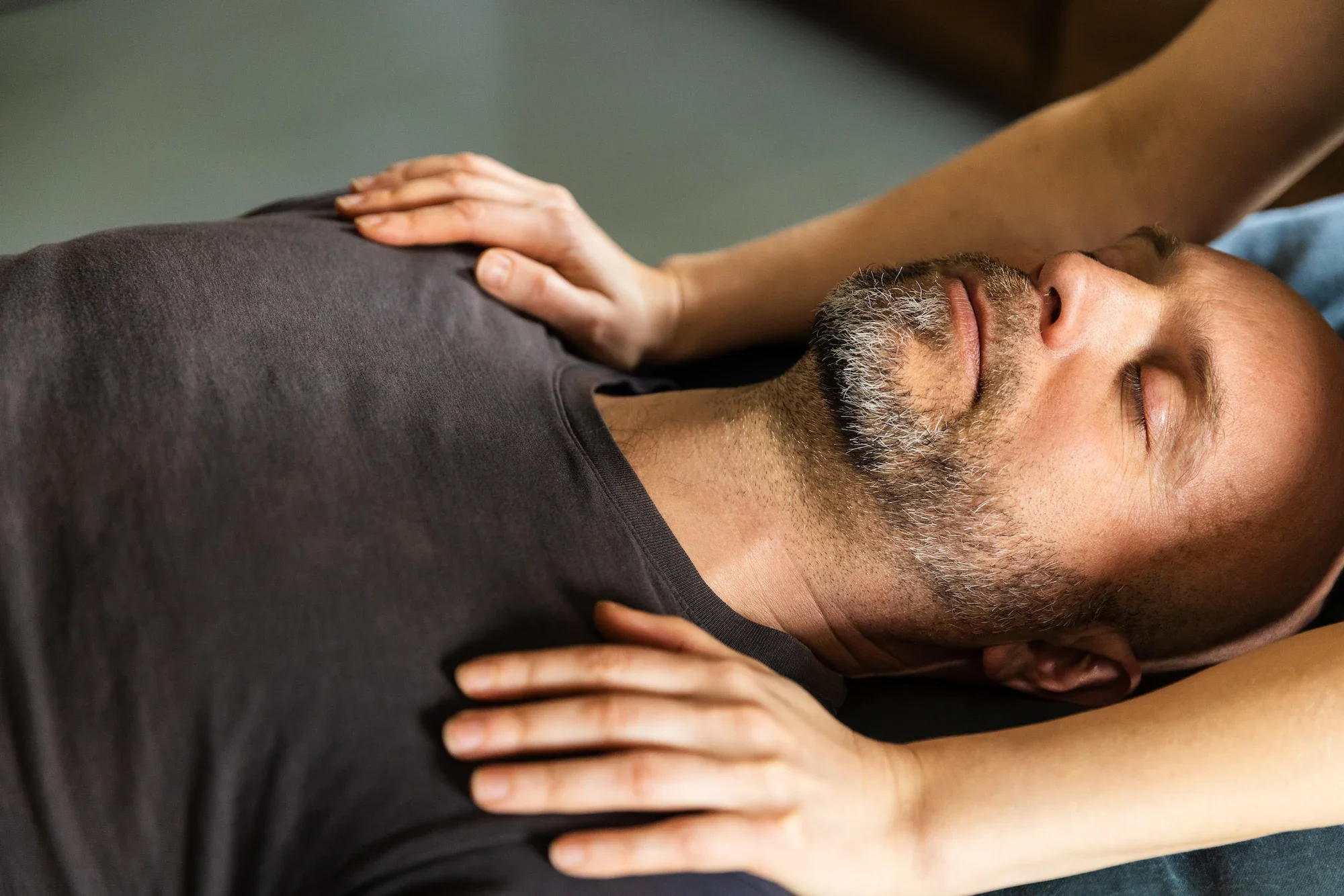 Osteopaatin kädet hoidettavan hartioilla