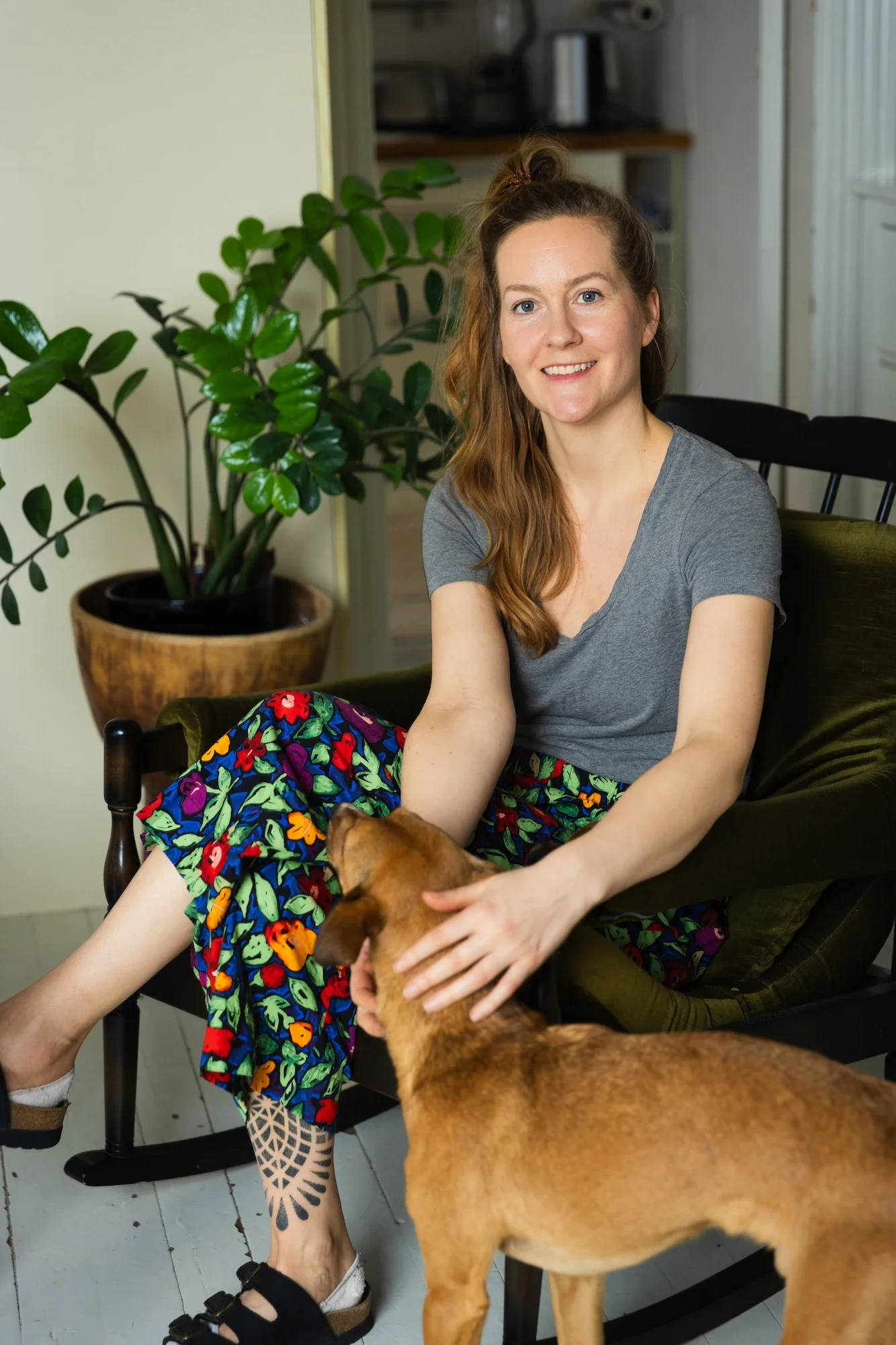 Osteopaatti istuu ja hymyilee koiran kanssa