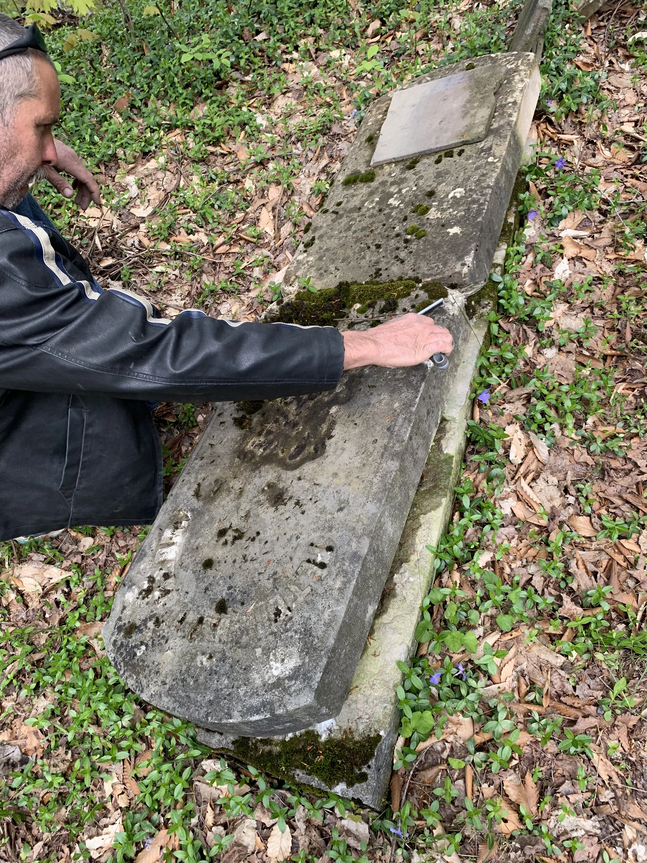 Inspecting gravestone monument in need of resotration
