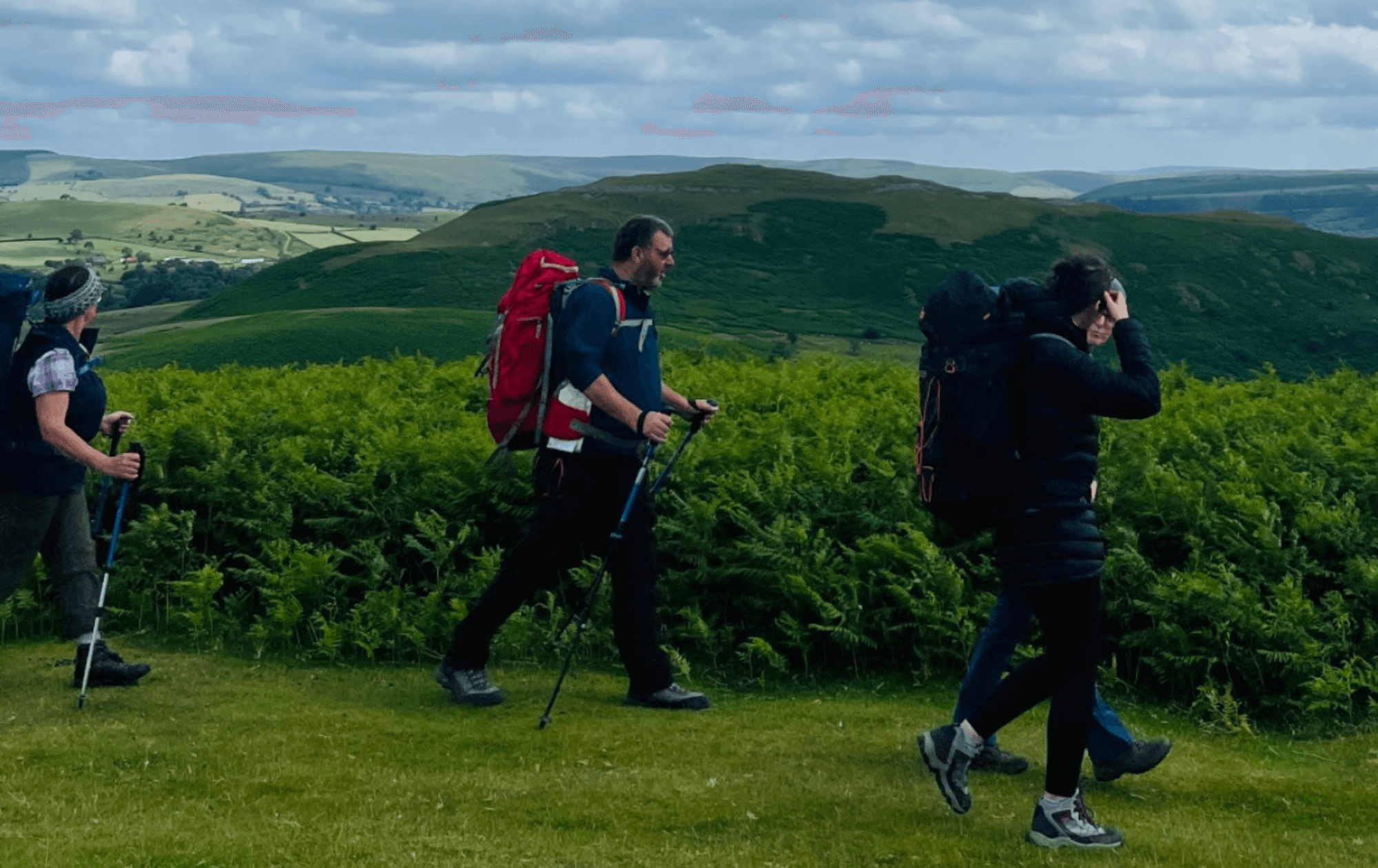 4 people trekking through the Cambrian Mountains on their wilderness expedition.