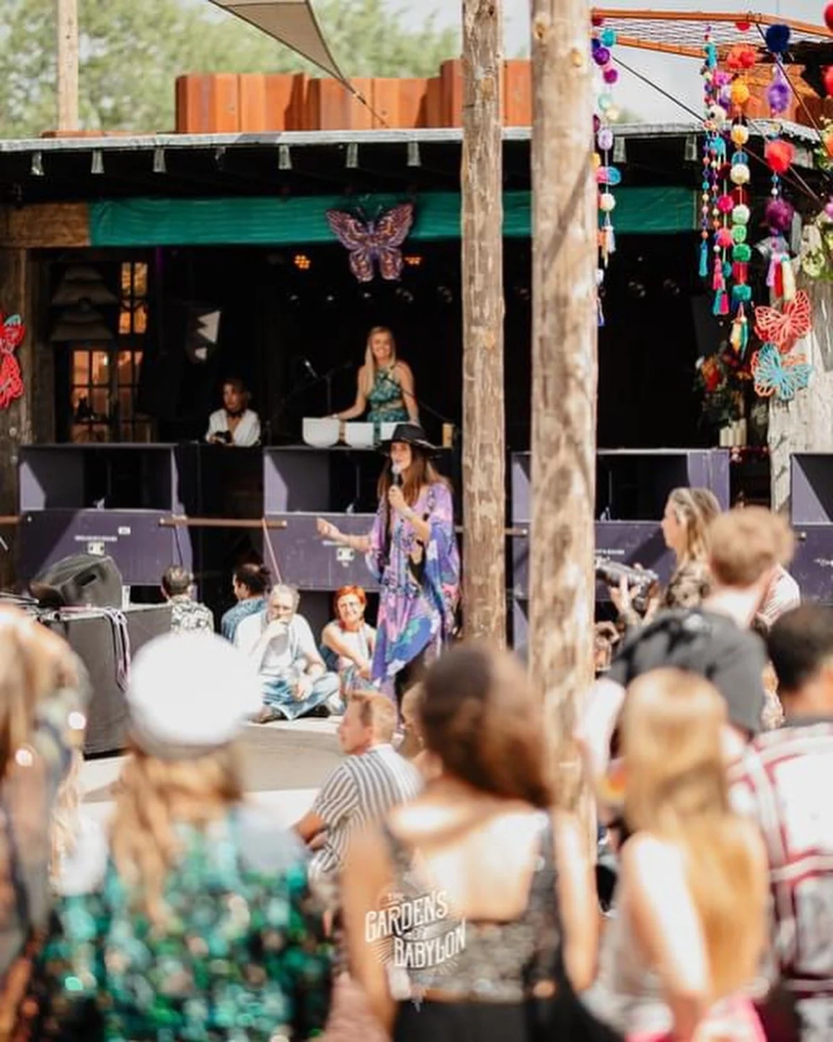 Olivia Pauline playing crystal singing bowls on stage at The Gardens of Babylon festival opening ceremony