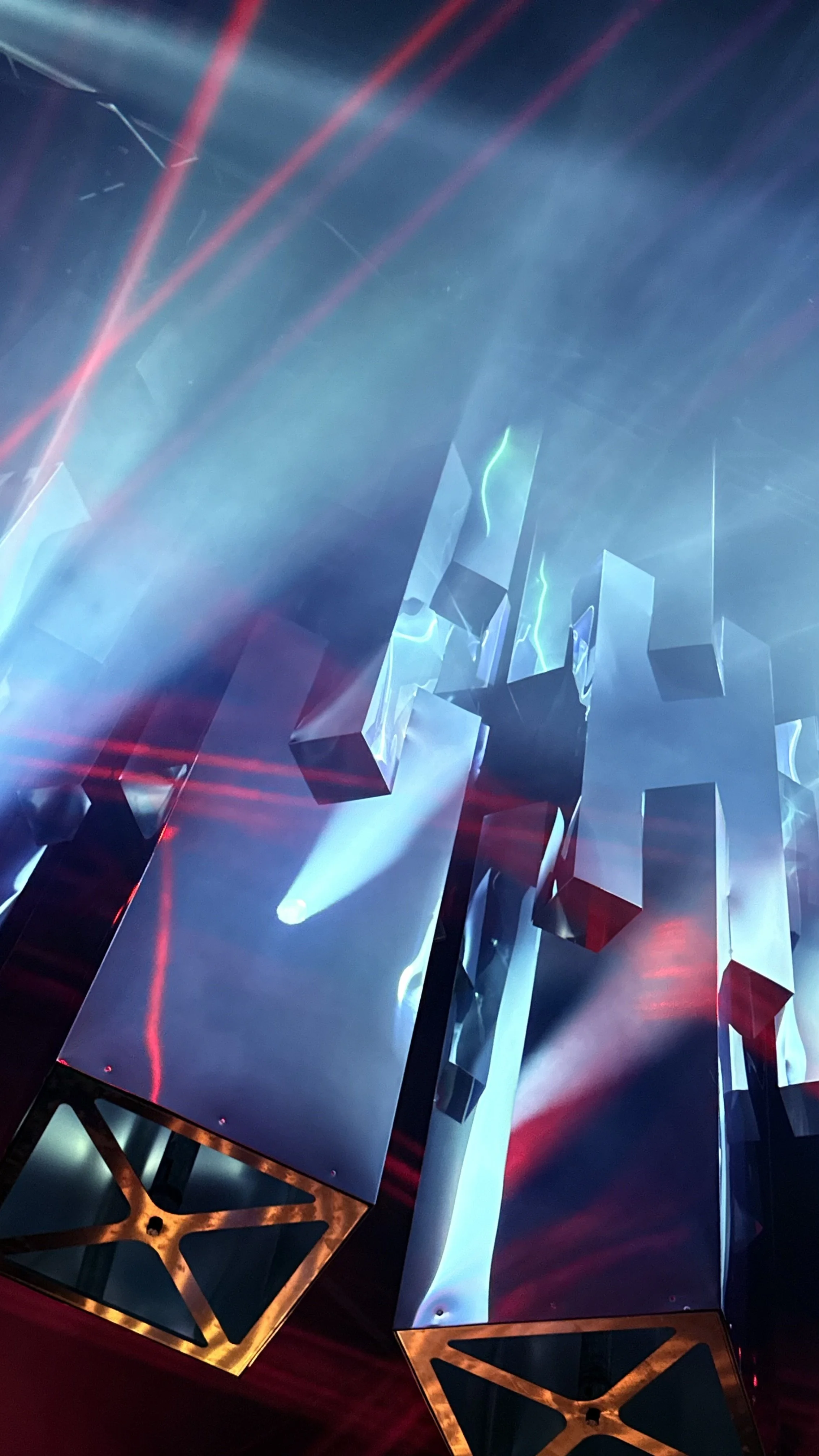 Abstract art installation with reflective surfaces, colorful lighting, and geometric shapes. Reflecting Bodies VI Voodoo Village Belgium Scenography art installation light installation Simone Smelt Lumus Instruments Festival main stage