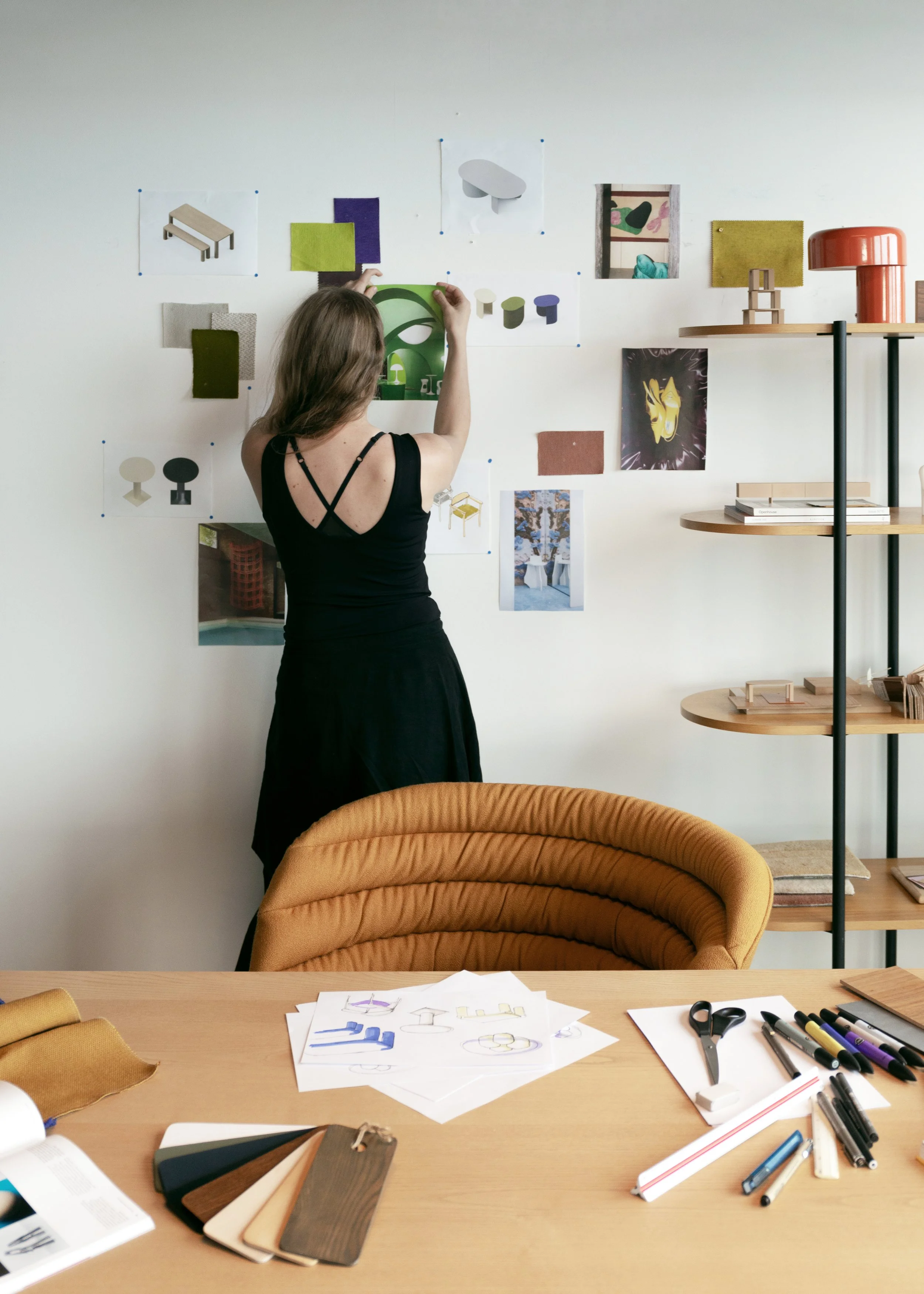 Simone Smelt hanging inspiration pictures in her design studio in amsterdam
