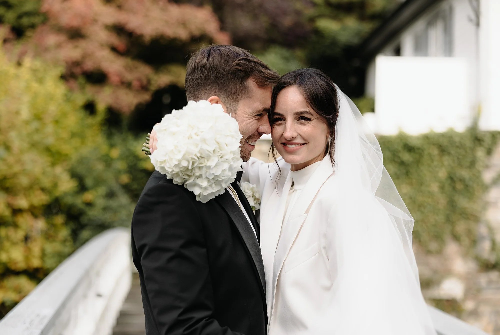 Braut und Bräutigam schmiegen sich an einander, fotografiert in Monschau auf einer historischen Brücke.