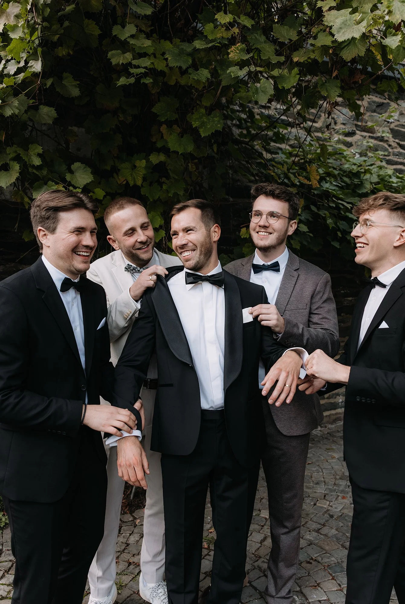 Der Bräutigam mit seinen Groomsmen, wie sie ihn herrichten und schauen ob alles sitzt.
