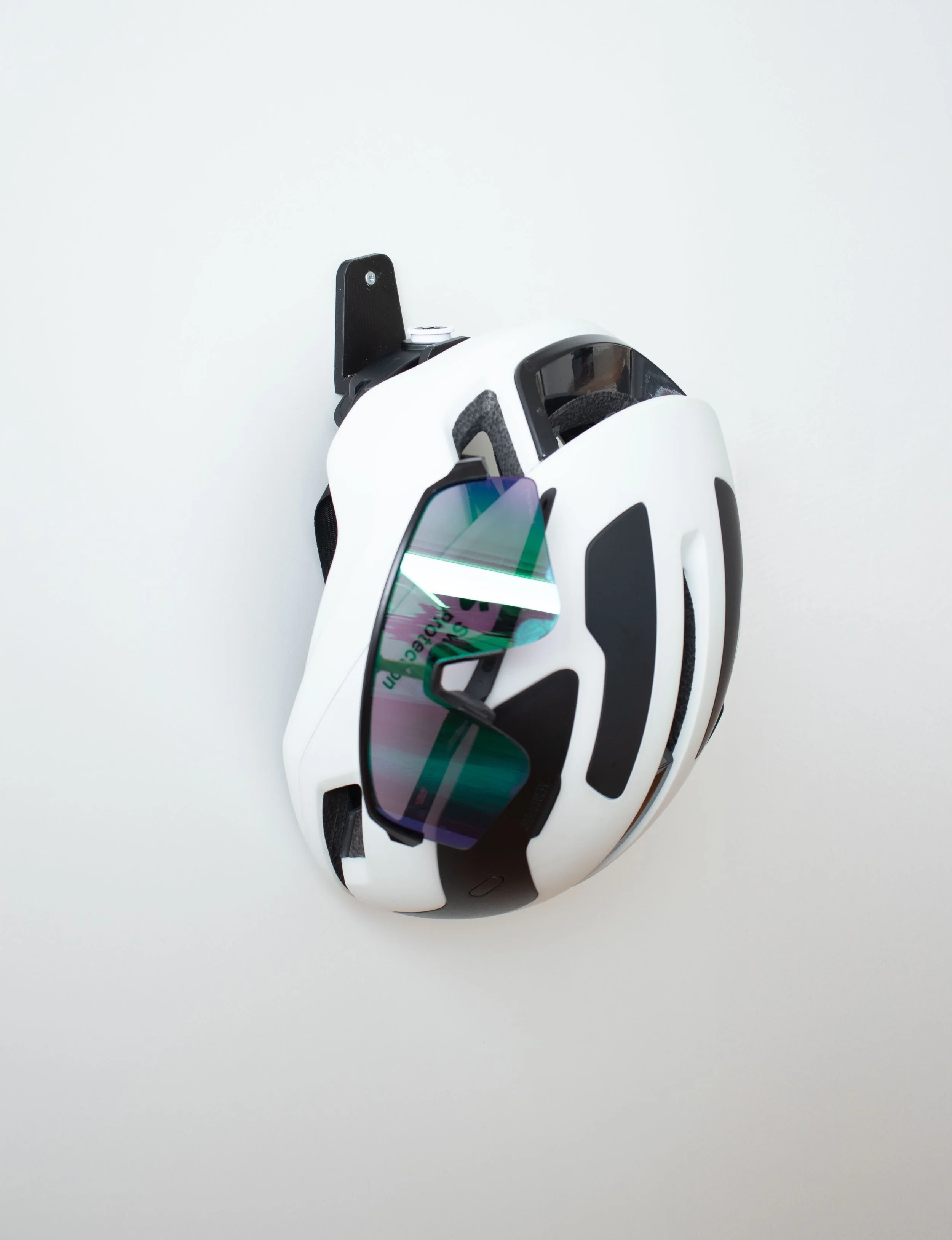Casque de vélo Sweet Protection et lunettes cyclisme Oakley accrochés à un support mural design