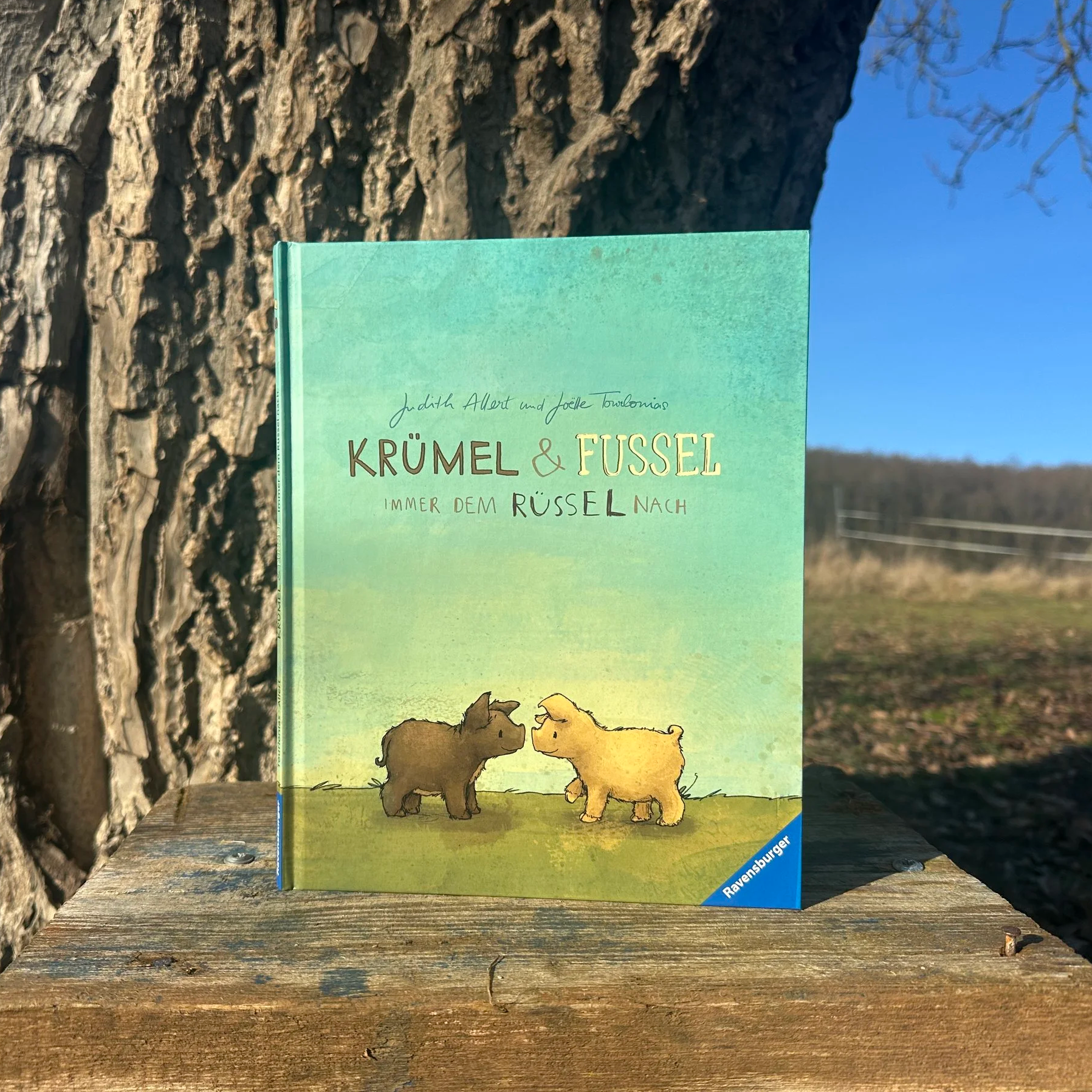 Das Bilderbuch "Krümel und Fussel". Es zeigt zwei kleine Wollschweinferkel.