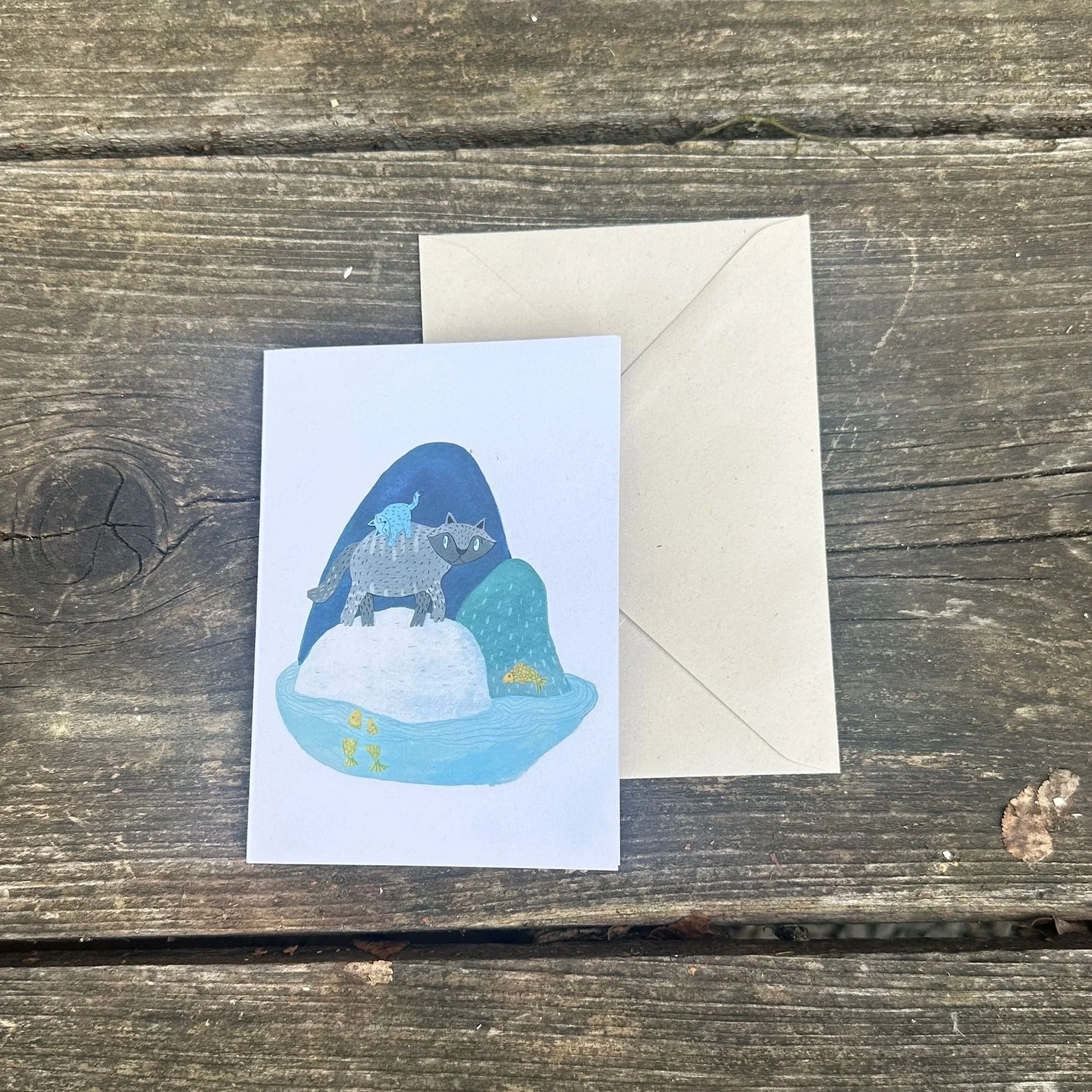 Die Grußkarrte "Insel" liegt mit einem Umschlag auf einem Tisch.