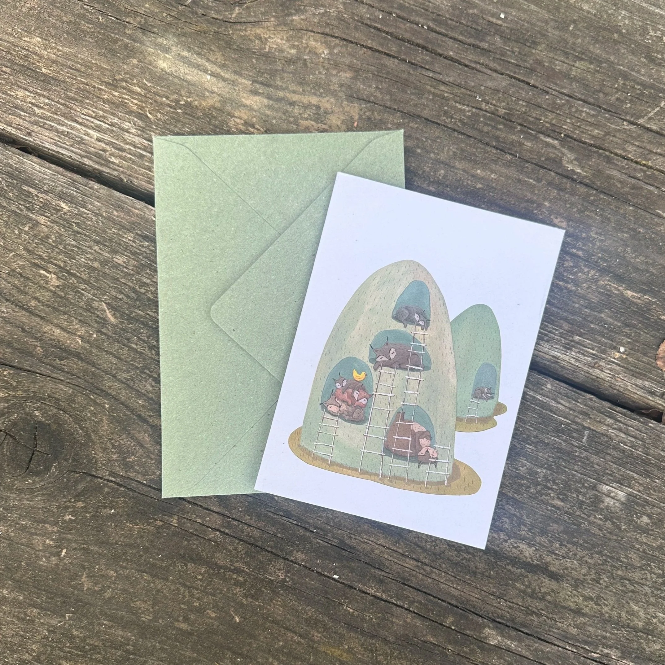 Die Grußkarte "Luchsbau" mit Umschlag flach auf einem Tisch.