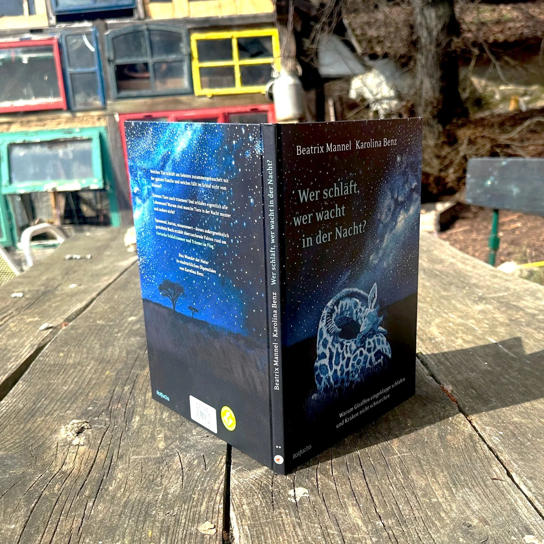 Das Buch "Wer wacht, wer schläft in der Nacht" steht aufrecht auf einem Tisch.