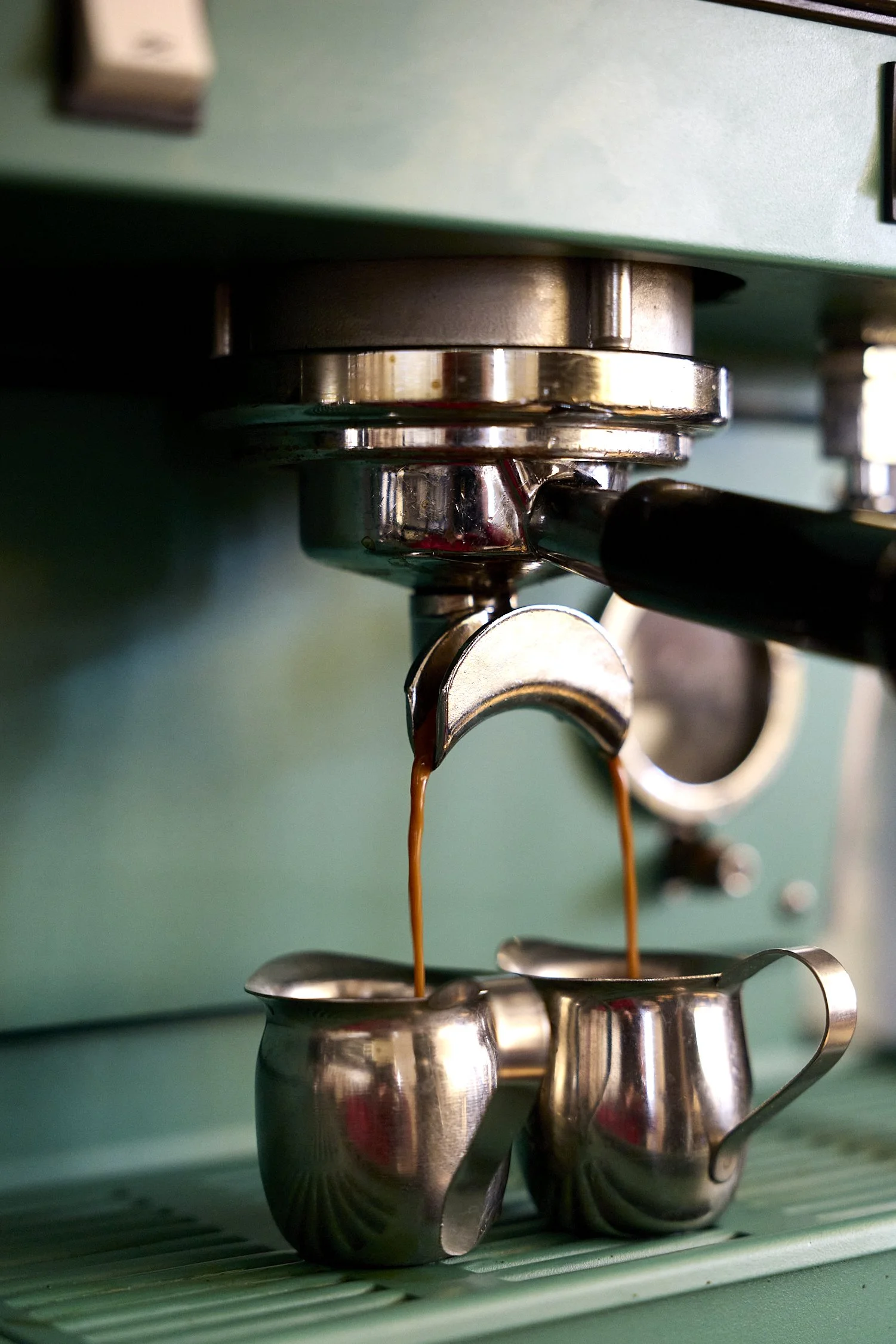 Close-up of an espresso machine pouring dark coffee into a cup.