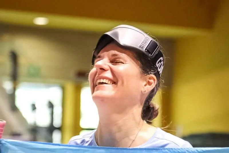 Lachende vrouw met geblindeerde bril op haar voorhoofd