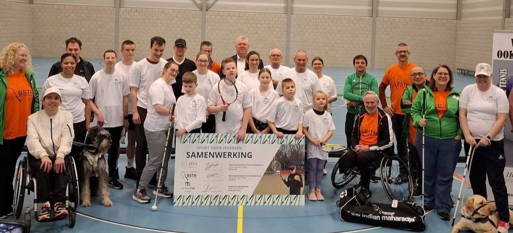 Groepsfoto met banner van samenwerking.