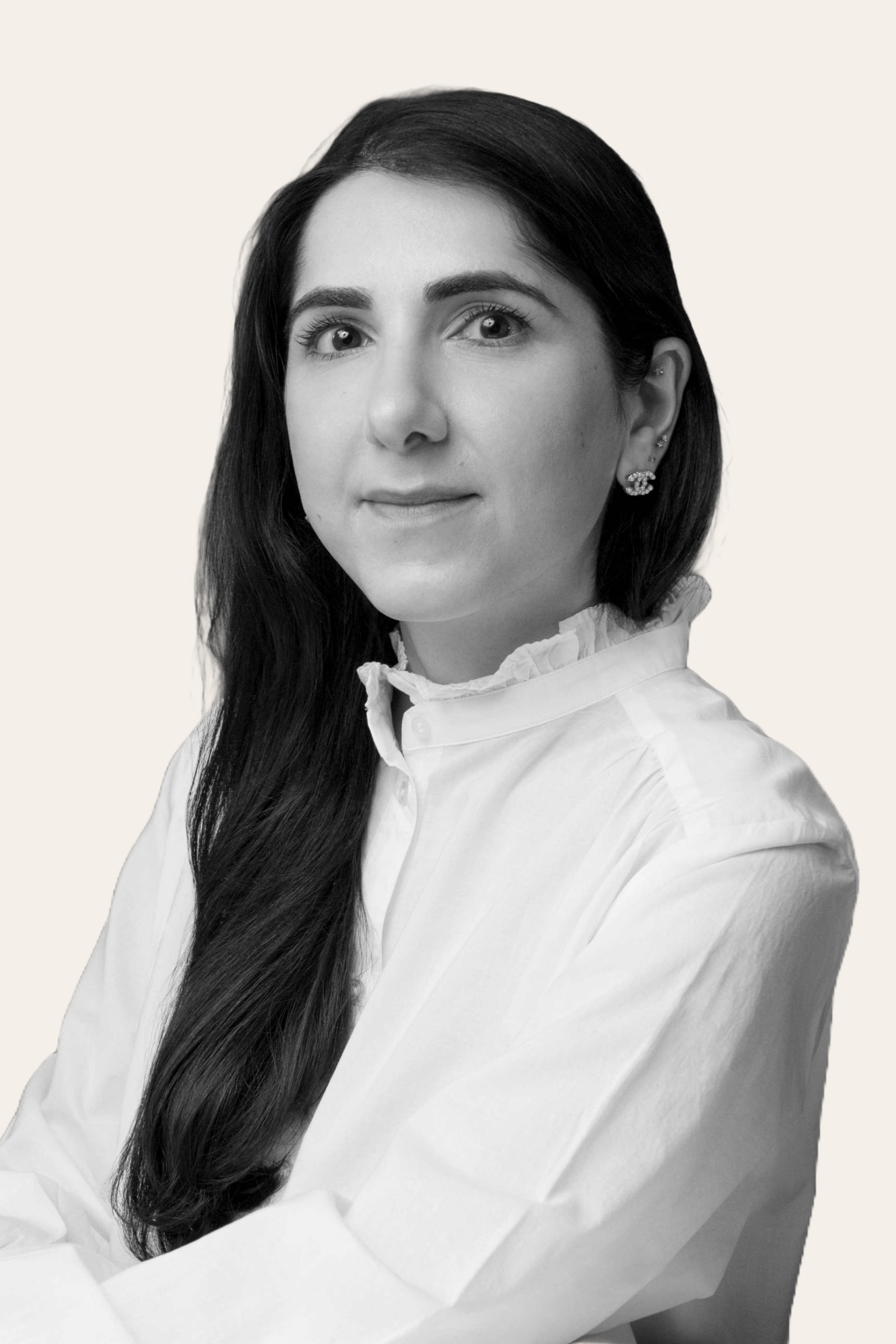 Black and white portrait of a woman with long hair wearing a white blouse on a light background