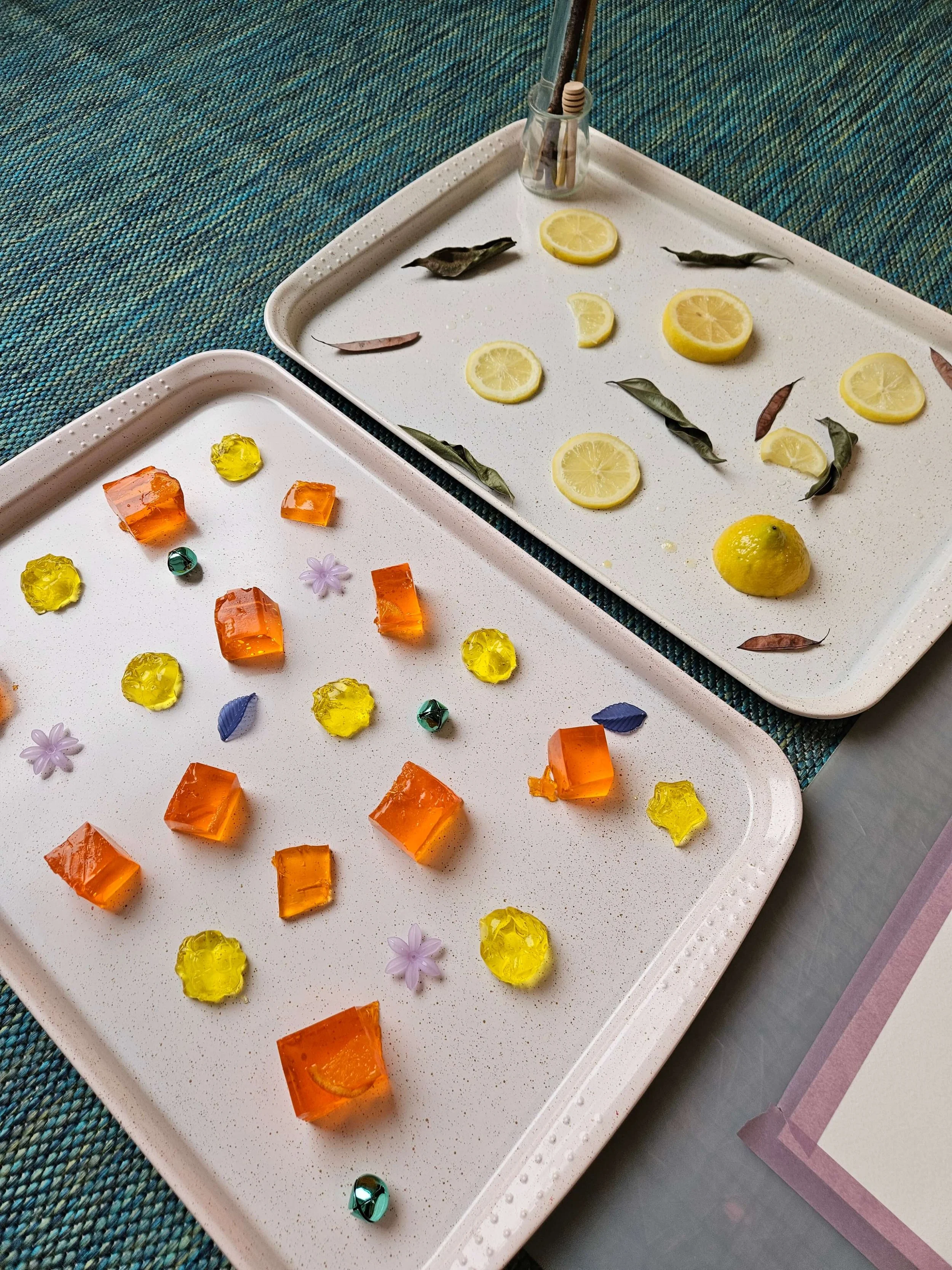 Toddler sensory activity with citrus slices and colored ice cubes on trays