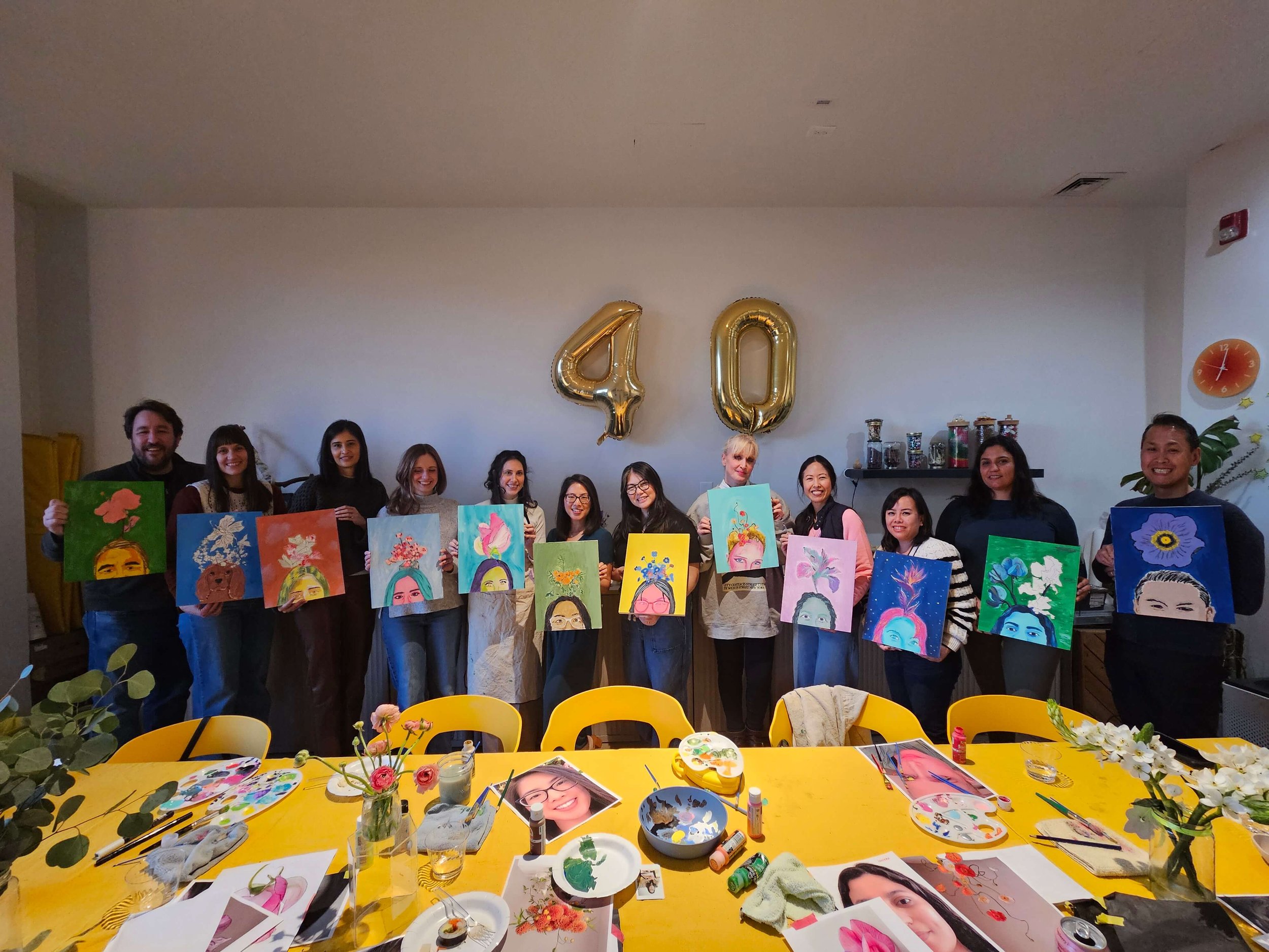 Group of adults holding completed portrait paintings during a birthday art workshop at Whimsy Art Club studio in Fort Lee, NJ.