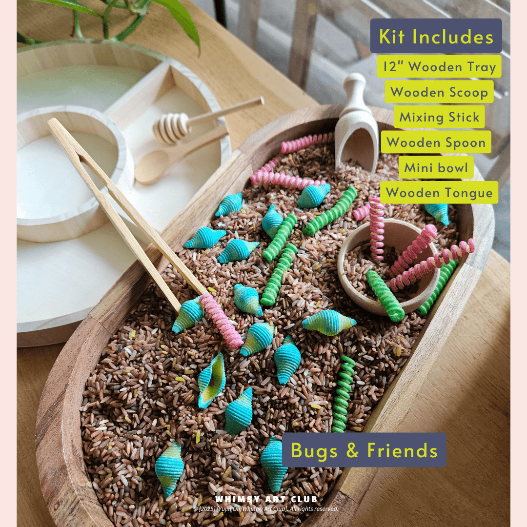 Wooden tray filled with brown rice and colorful pasta shaped like bugs, with wooden scoop, tongs, and spoon included.