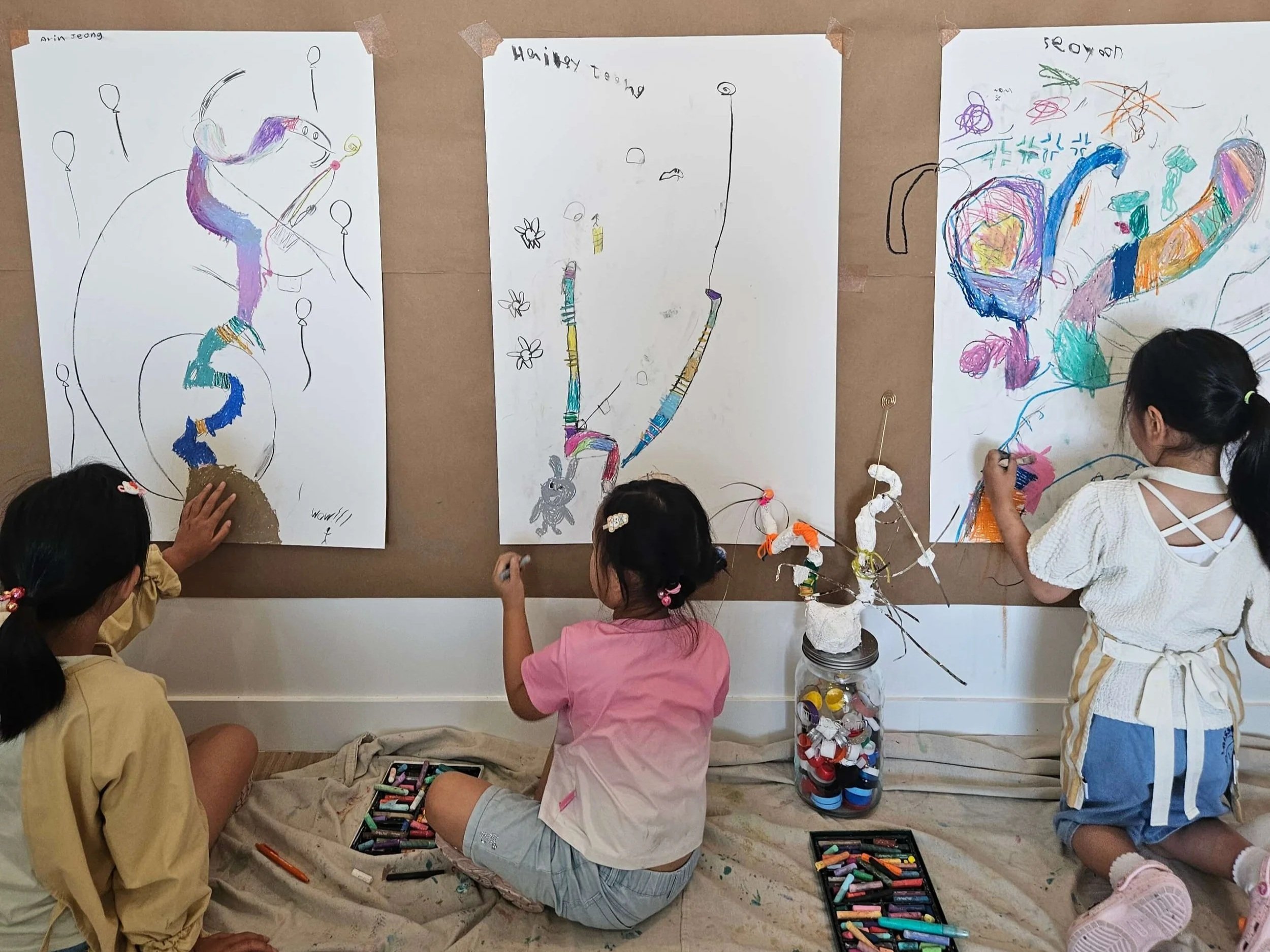 Photo of kids drawing on a large canvas
