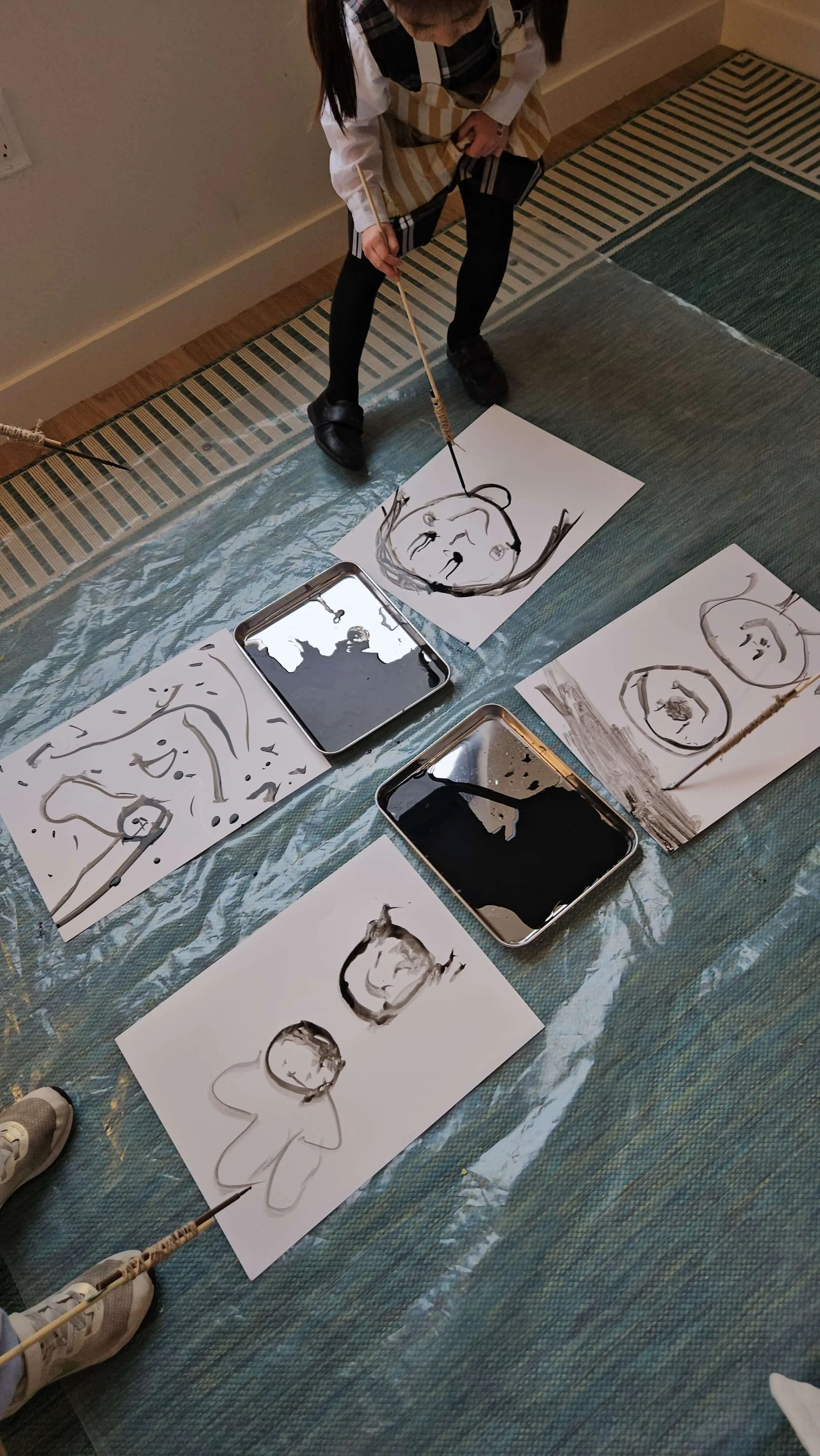 Children exploring expressive painting using long brushes during a process art class at Whimsy Art Club in Fort Lee, NJ.