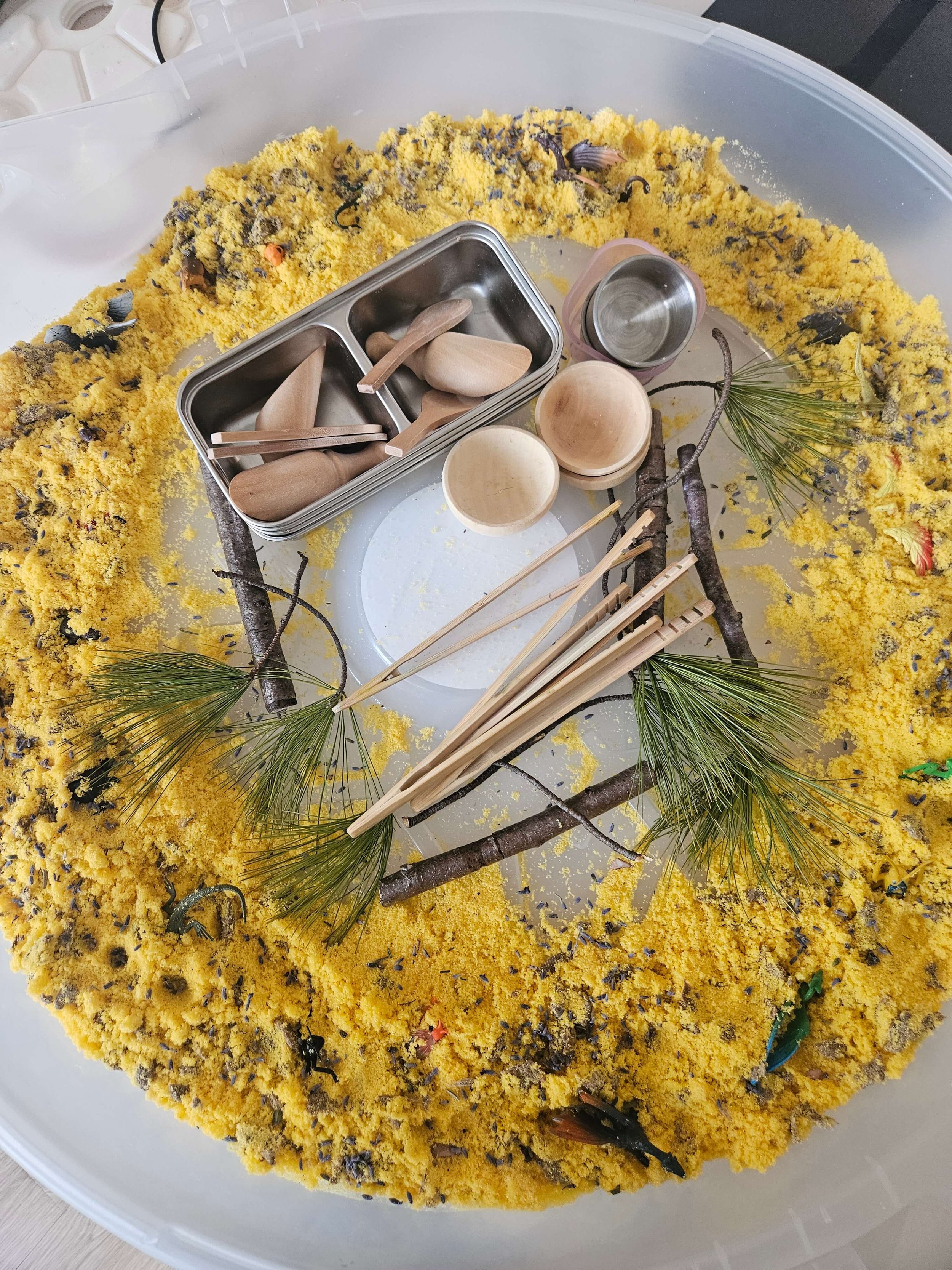 Sensory bin activity for toddlers with scoops, wooden bowls, and natural materials
