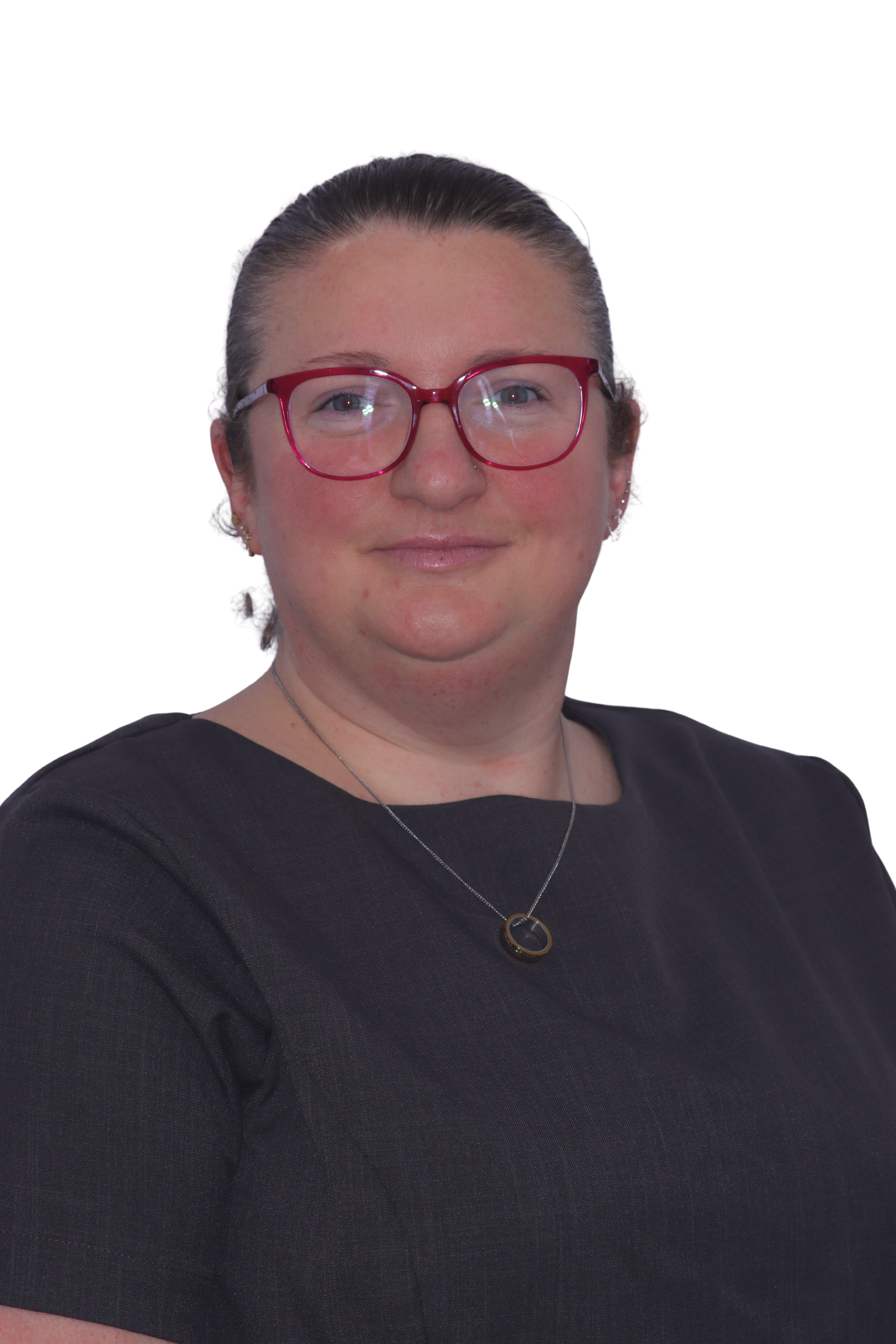 Person with glasses smiling, wearing a black sweater and earrings, posing in front of a plain background.
