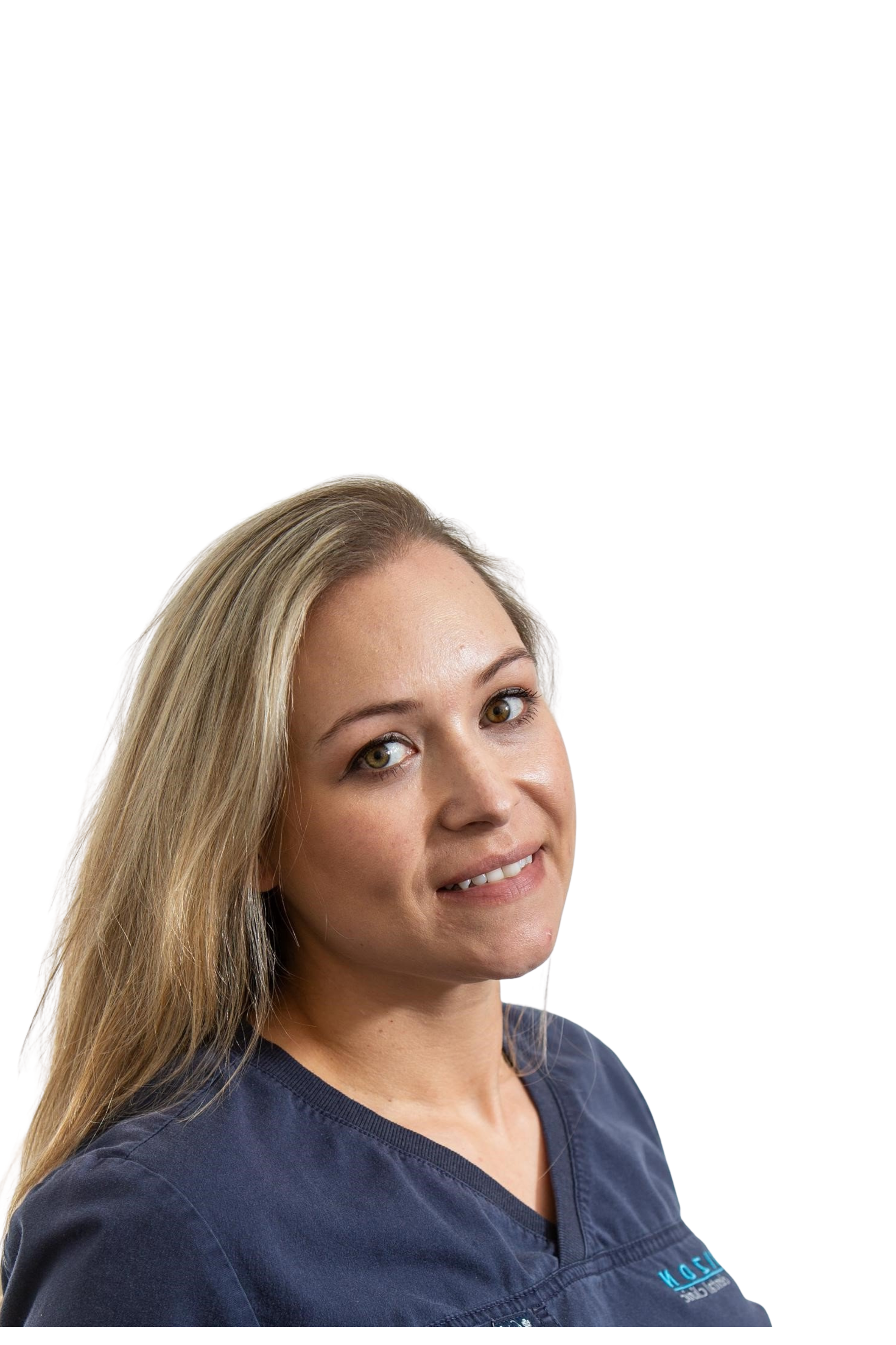 Woman in gray scrub top smiling against a neutral background.
