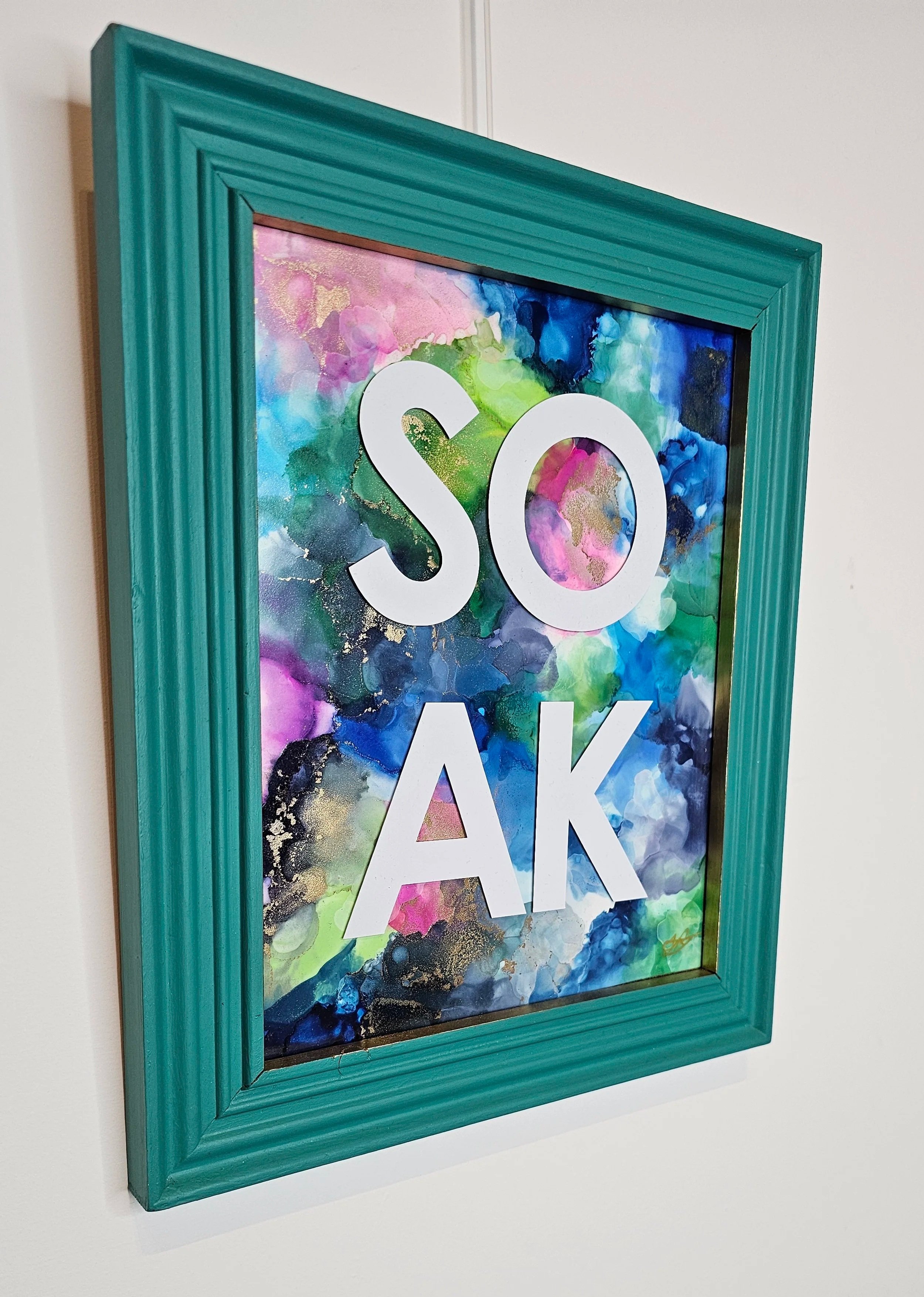 side view of Original alcohol ink bathroom art with blue and pink colors, upcycled mermaid green frame with the word SOAK