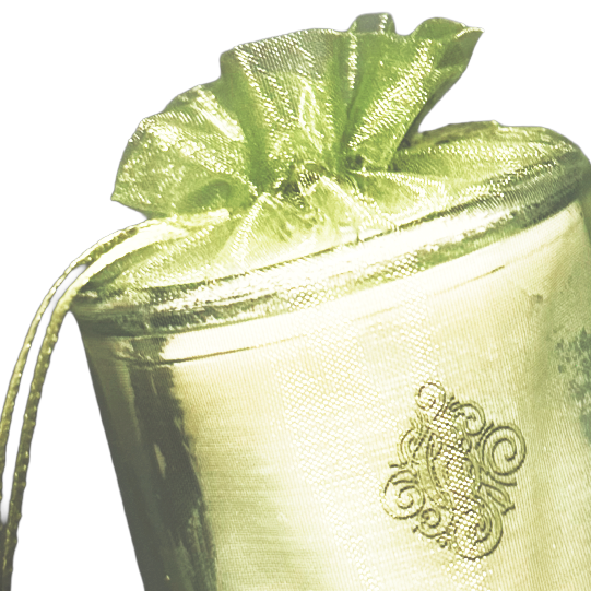 Close-up of a metallic gold-colored cocktail shaker with a garnish of a lime or lemon wedge, on a dark background.