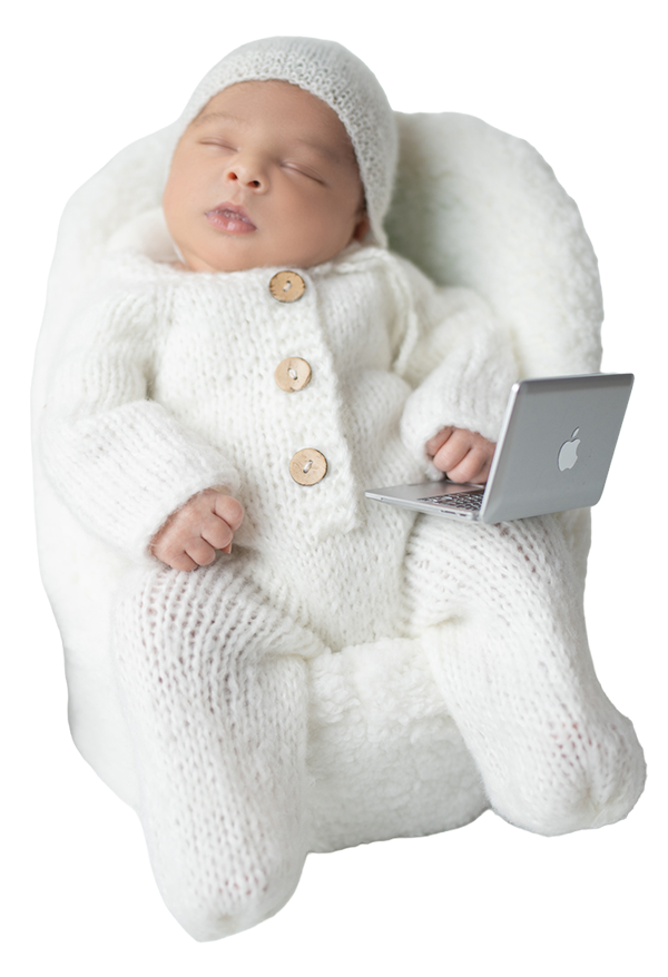 Ein schlafendes Baby in einem weißen Pullover und einer Mütze, das auf einem weißen Stuhl sitzt und eine kleine MacBook-Laptop hält.