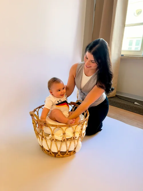Rossy begleitet ein Baby beim Fotoshooting im Studio.