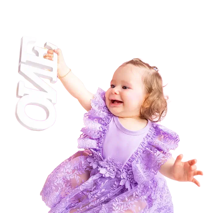 Lachendes Mädchen im lila Kleid hält einen weißen ONE-Schriftzug hoch.
