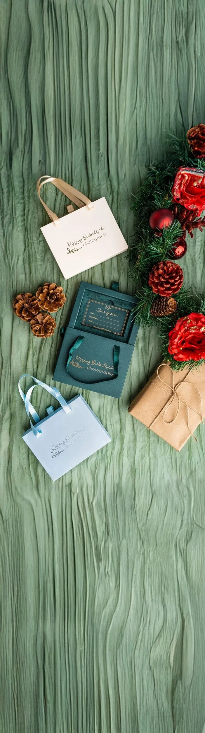 Geschenkboxen, Weihnachtsdeko mit Tannenzweigen, roten Weihnachtskugeln und Tannenzapfen.