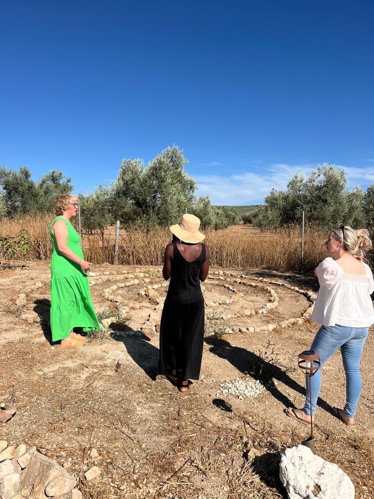 An ancient stone tomb entrance, surrounded by large boulders, with a blue sky overhead.