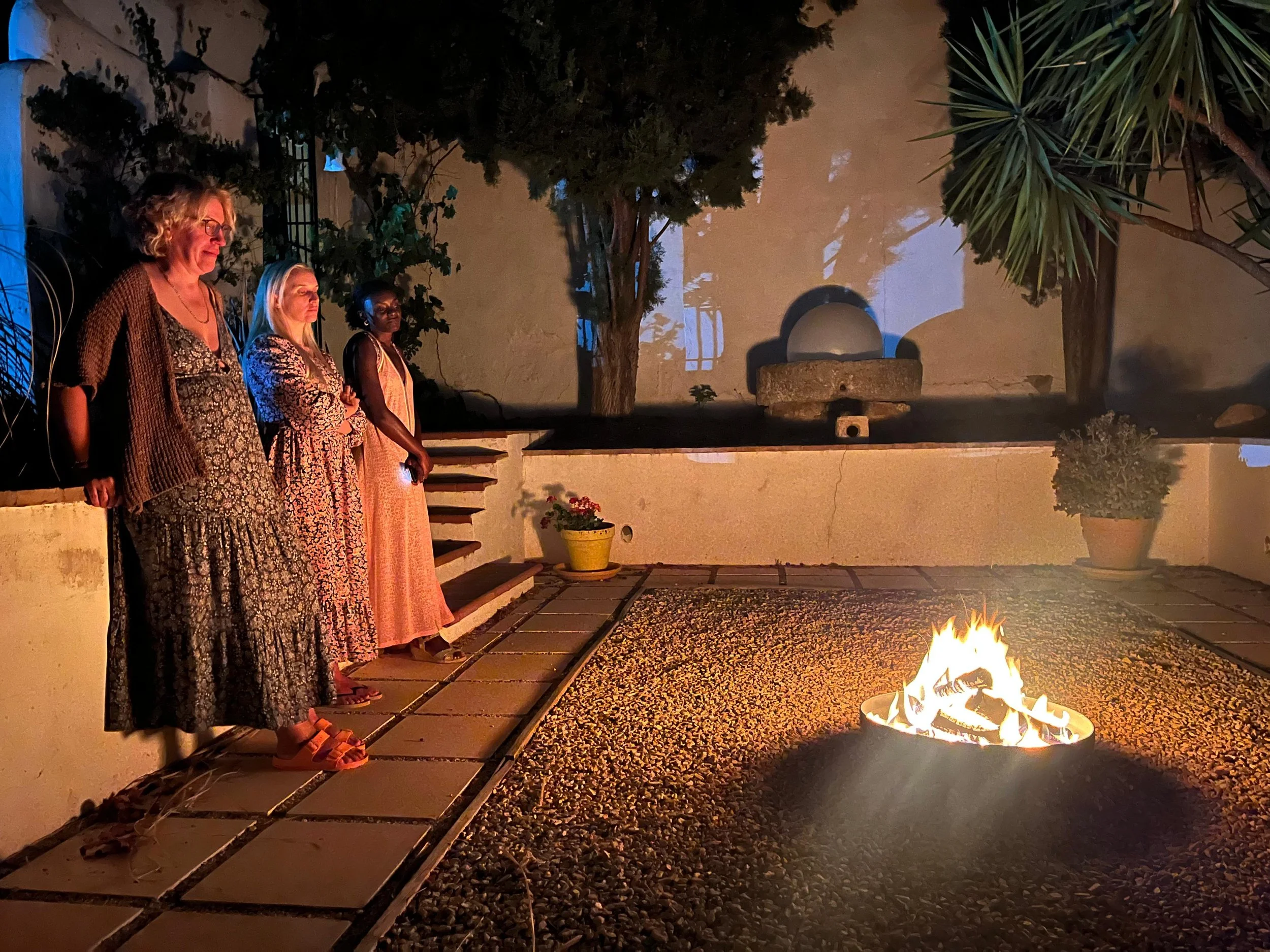 Person practicing yoga at sunrise on a wooden deck with natural surroundings.