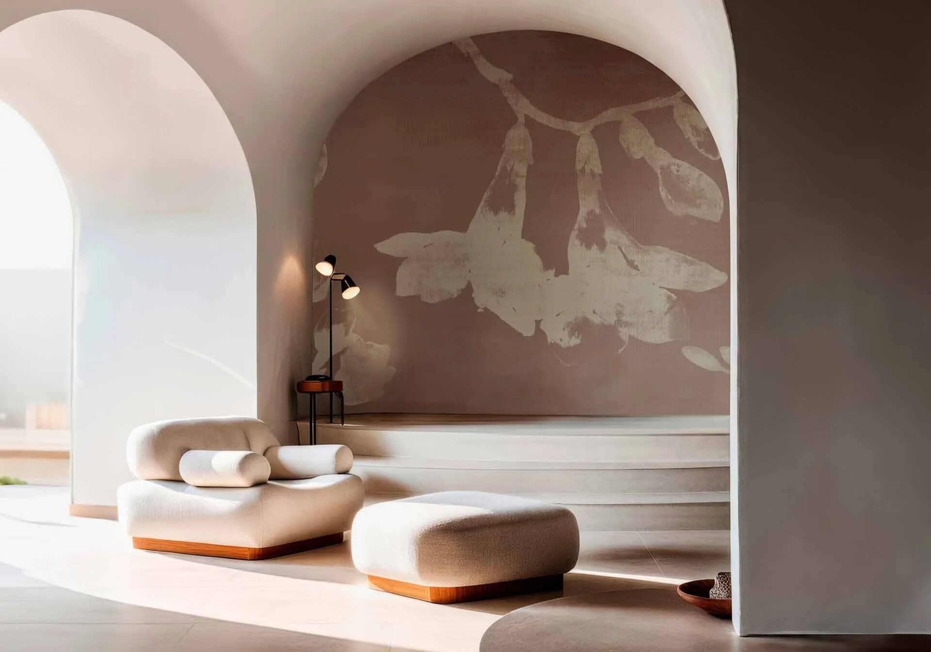 Soggiorno con divano e pouf bianchi, lampada da terra, parete con decorazione floreale, archi eleganti, spazio luminoso e minimalista.