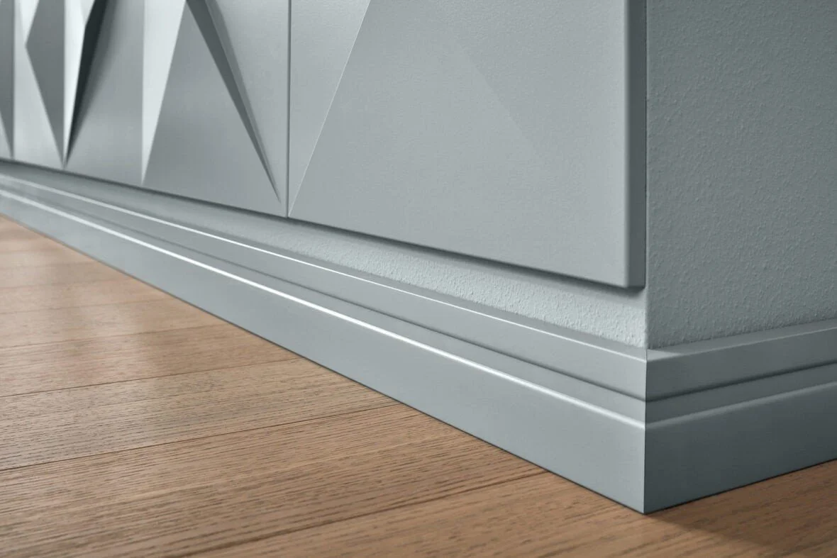 Dettaglio del bordo di una mobile moderna grigia e pavimento in legno.