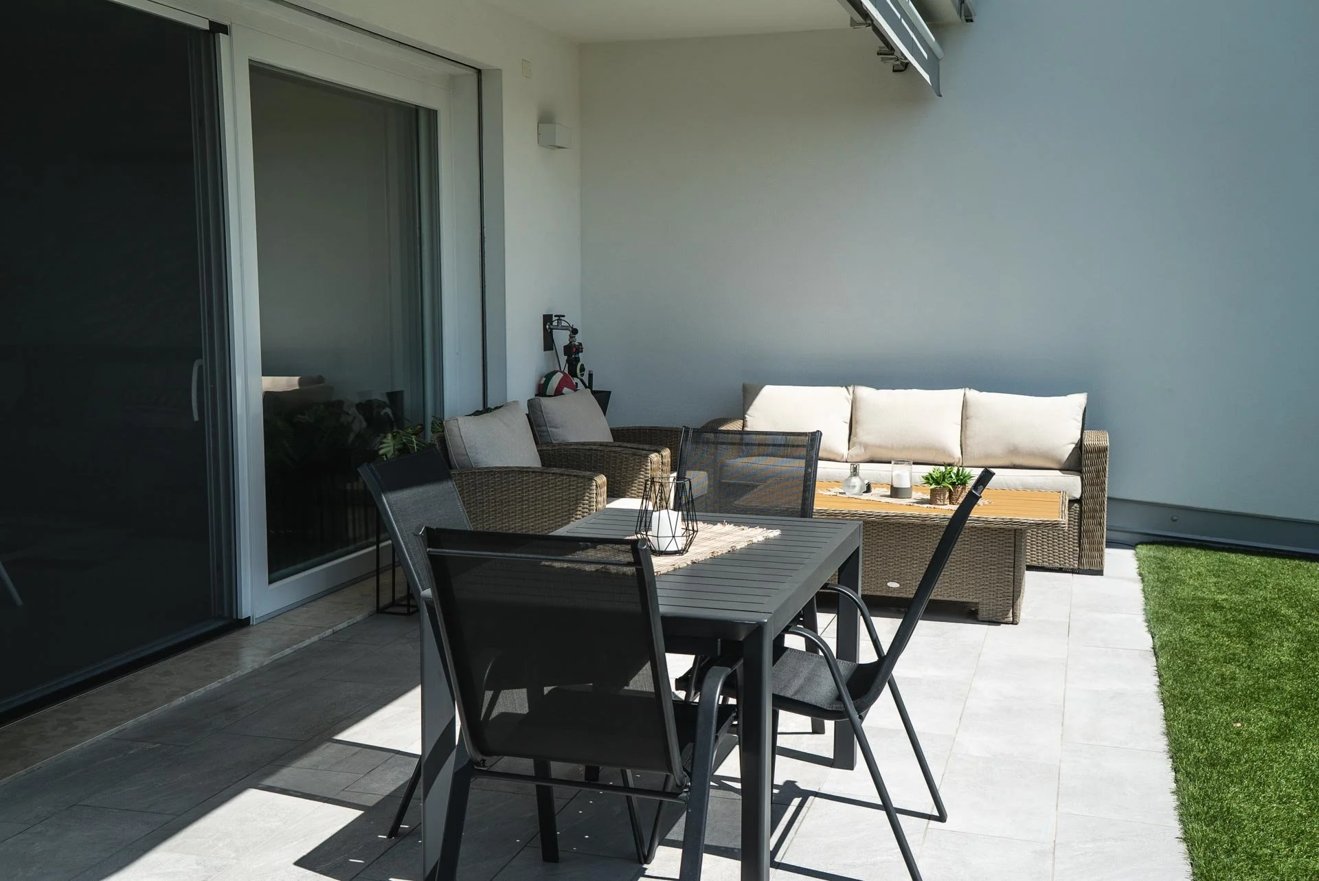 Terrazza con tavolo, sedie, sofa e decorazioni da esterno