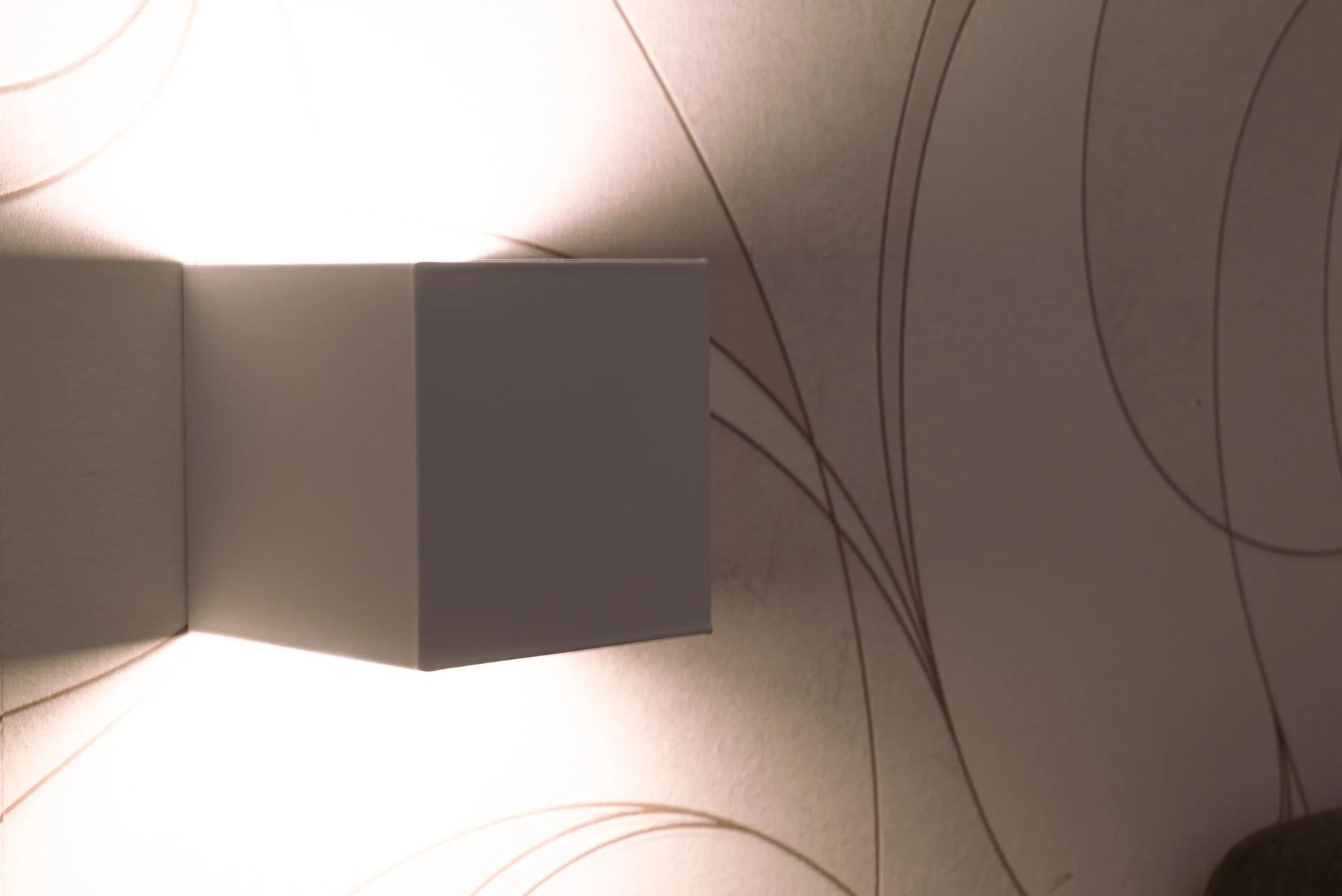 Stanza con pareti decorate con un motivo a linee curve e una lampada a soffitto bianca