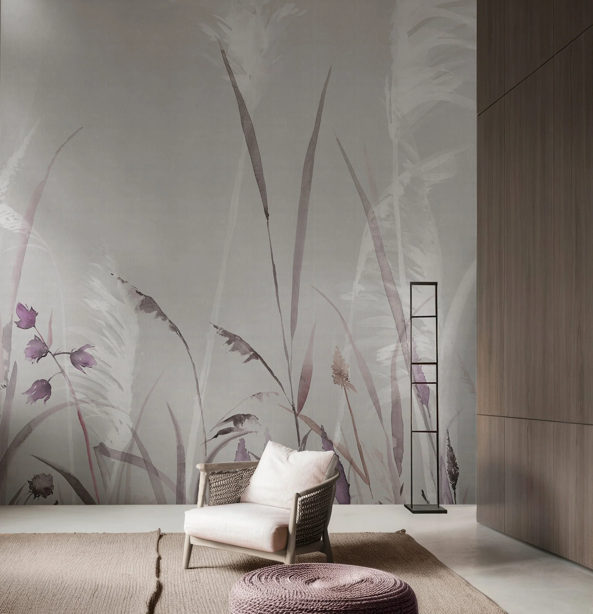 Interno con sedia imbottita, tappeto rotondo, parete decorata con stampa di piante in toni rosa e viola, scaffale a torre nera, pareti in legno