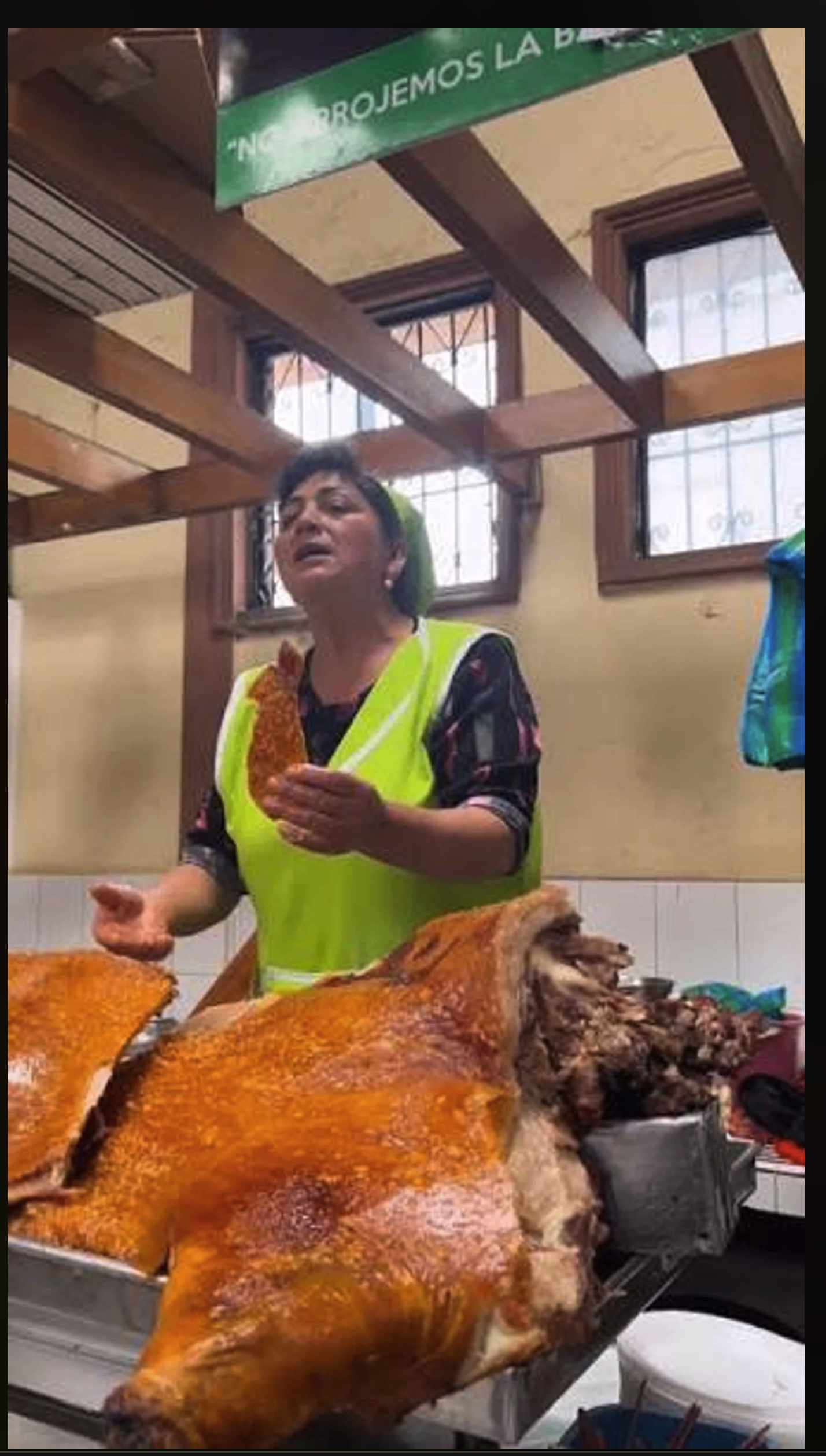 Foto original de una vendedora con un cerdo horneado, antes de aplicar el collage editorial con IA.