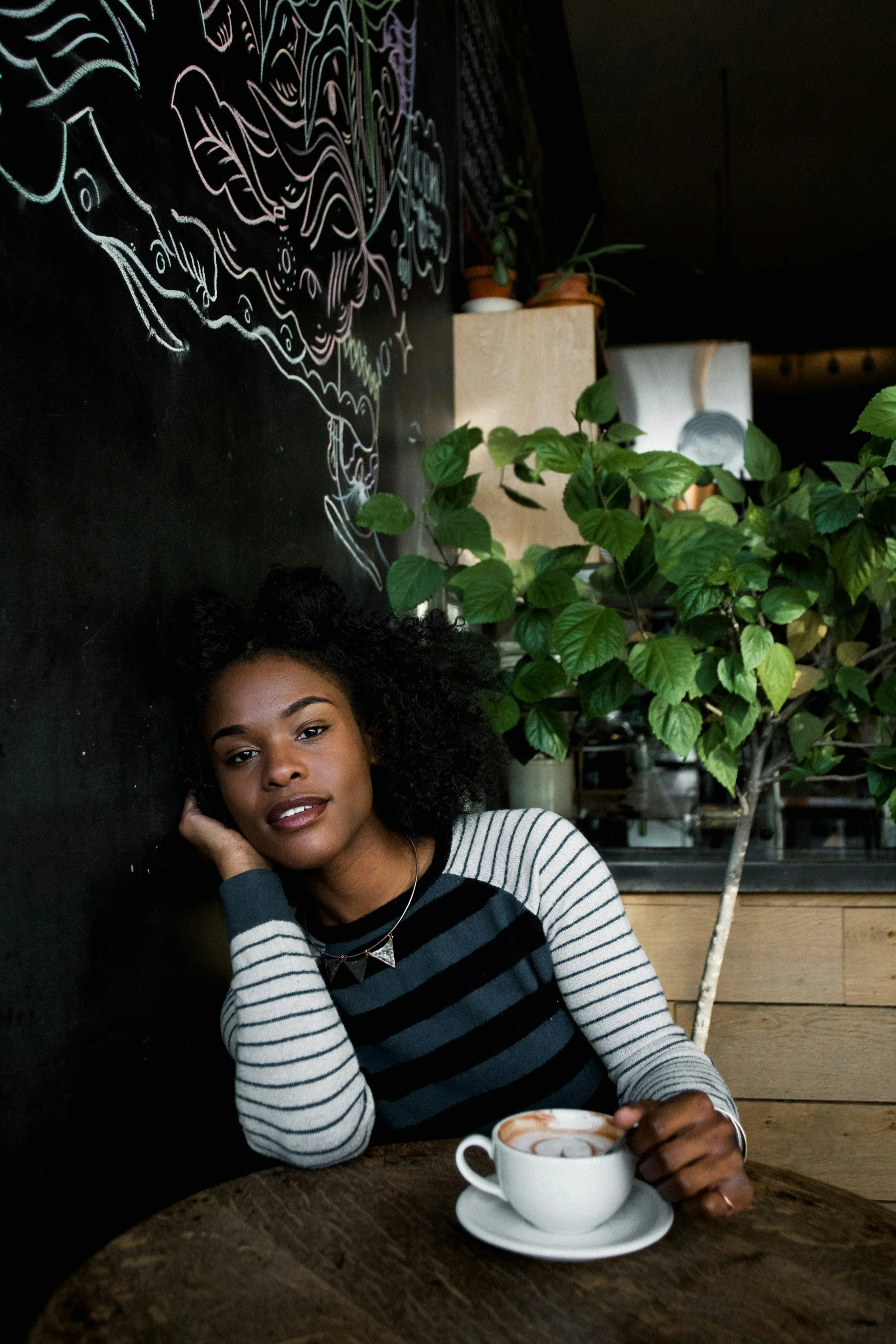 young, Christian woman sitting drinking coffee and is happy