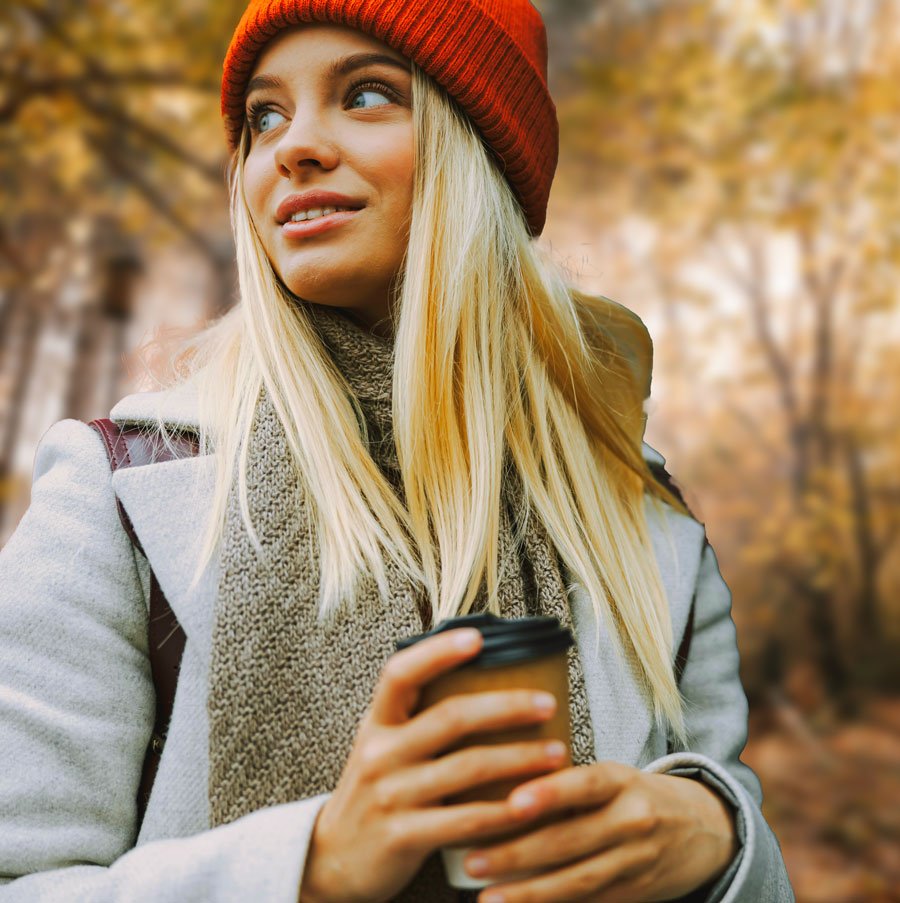 Woman with red hat, holding a cup of coffee.