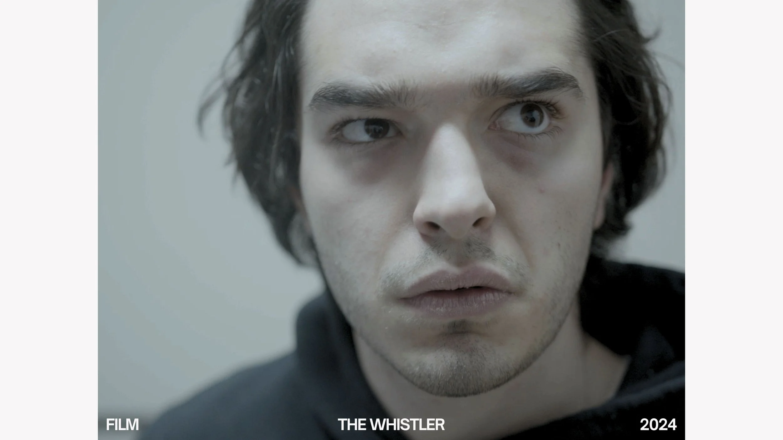 Close-up of a man's face with intense expression, dark hair, and light skin, looking to the side. Overlay text reads 'Film The Whistler 2024'.