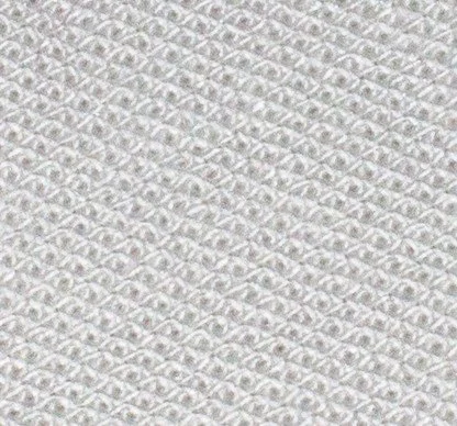 Close-up of textured white fabric or paper with a repeating pattern.