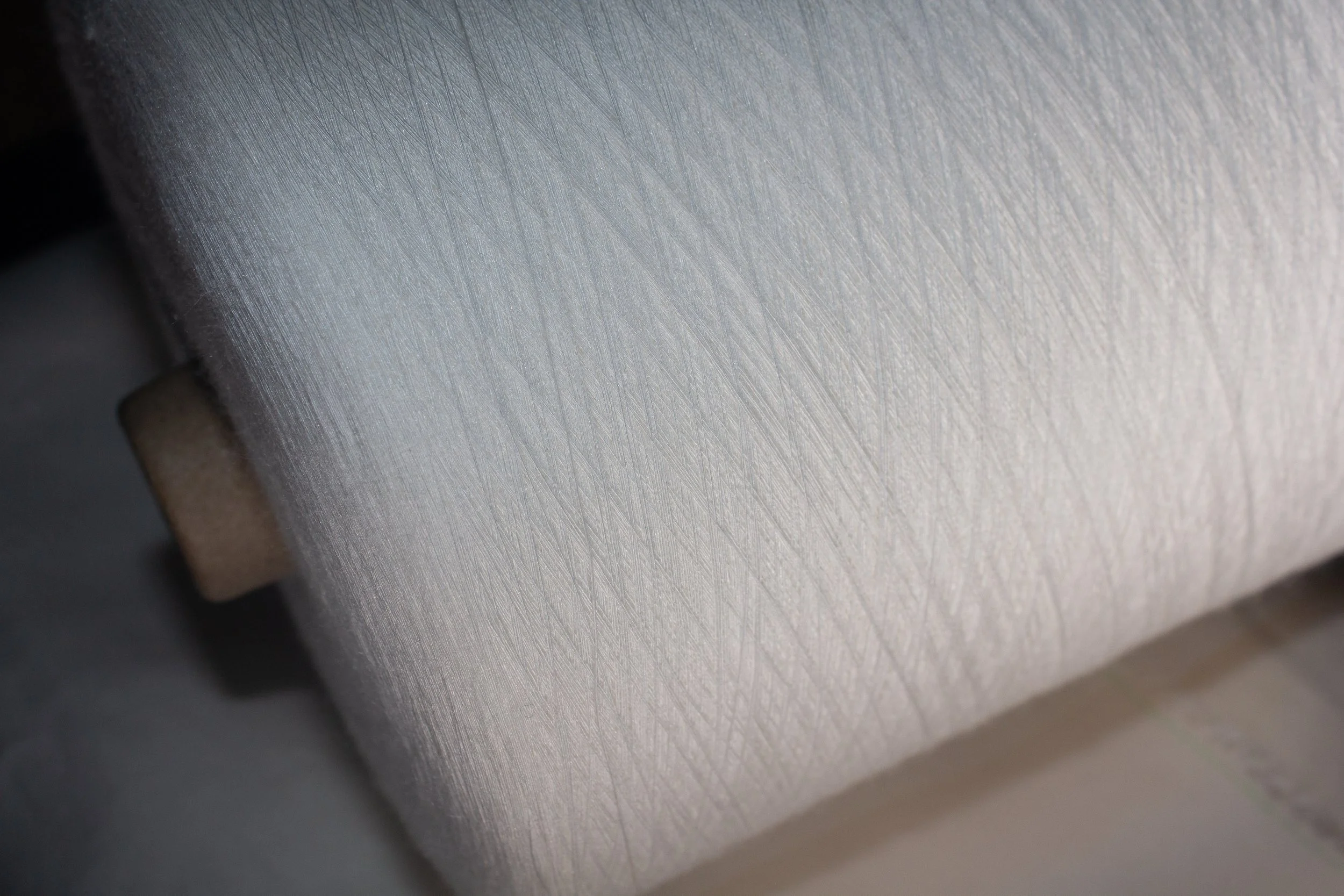 Close-up of a SeiYarn cone presented under a soft light.