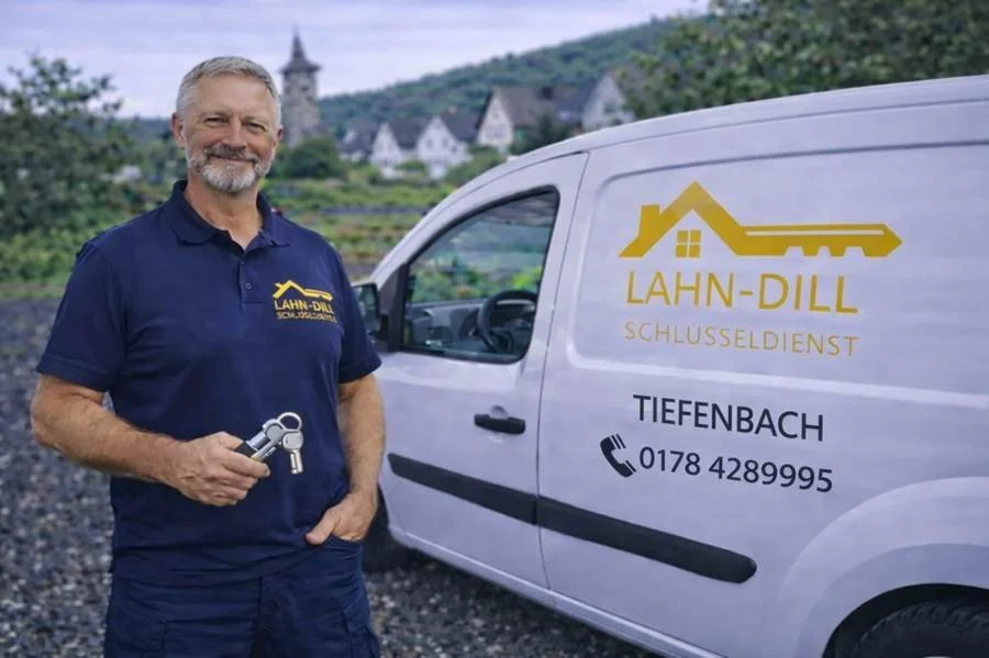 Schlüsseldienst Lahn-Dill Mitarbeiter mit Schlüsselbund vor Servicefahrzeug in Tiefenbach