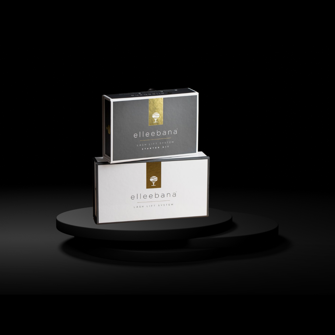 Two Elleebana Lash Lift System starter kits, one on top of the other, displayed on a black circular platform against a dark background.